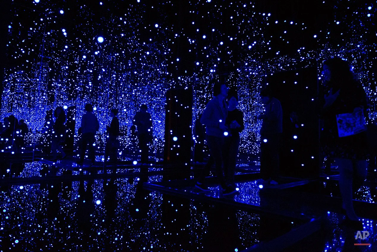  Journalists walk through an installation by Japanese artist Yayoi Kusama during a press tour of her "Infinite Obsession," exhibit, at the Rufino Tamayo Museum in Mexico City, Mexico, Tuesday, Sept. 23, 2014. The retrospective exhibit, which marks th