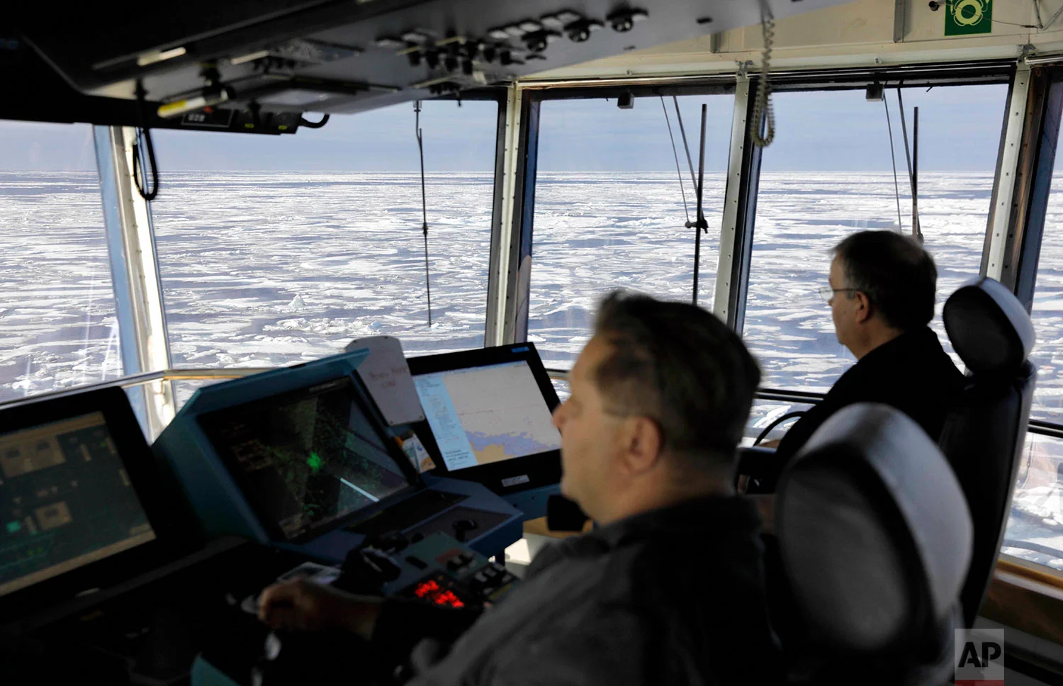 Master Mariner Jyri Viljanen, left, captain of the Finnish icebreaker MSV Nordica and Chief Officer Harri Venalainen, navigate from the bridge through ice floating on the Chukchi Sea off the coast of Alaska while traversing the Arctic's Northwest Passage, Sunday, July 16, 2017. More than a century has passed since the first successful transit of the treacherous, ice-bound Northwest Passage by Norwegian explorer Roald Amundsen in 1906. (AP Photo/David Goldman)