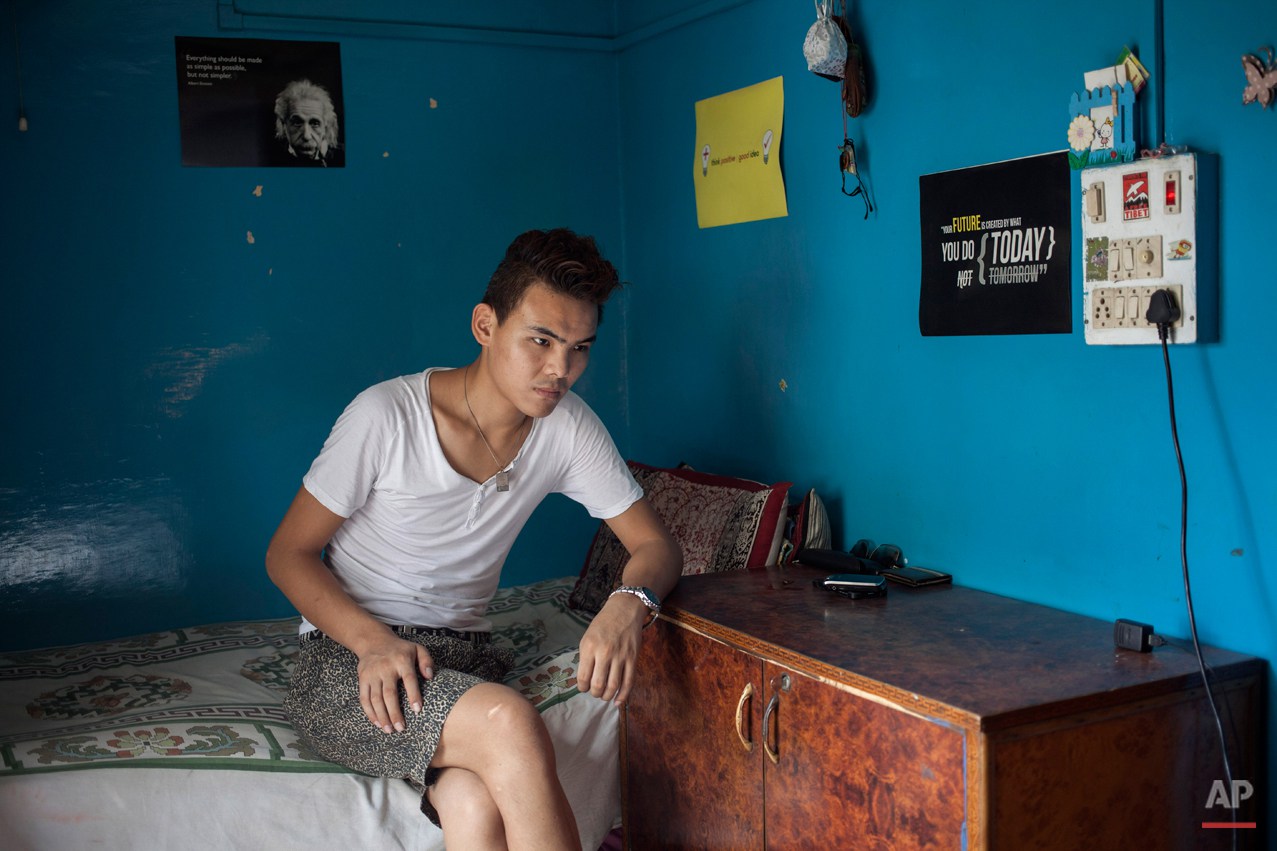  In this Wednesday, July 30, 2014 photo, Tibetan exile Kalsang Tsering, 20, sits in his room in New Delhi, India. Tsering said he missed his family when he was ill and in hospital with nobody to care for him. He now rents a room from a woman who trea