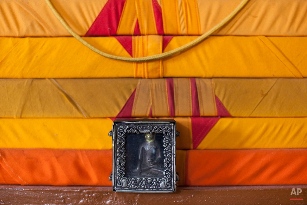  In this Tuesday, Sept. 30, 2014 photo, an amulet containing a Buddha statue stands near scriptures in the home of Tibetan exile Sonam Gyaltsen, 44, near Dharamsala, India. Gyaltsen, who is now a member of the Tibetan parliament-in-exile, carried the
