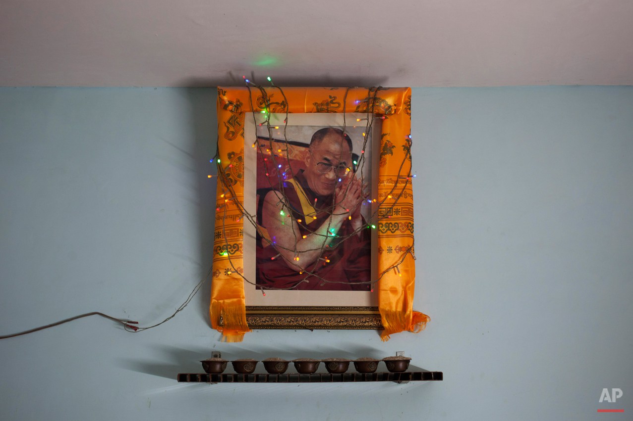  In this Tuesday, Oct. 28, 2014 photo, a portrait of Tibetan spiritual leader the Dalai Lama hangs on a wall in a restaurant in New Delhi, India. Since the Dalai Lama fled a failed 1959 uprising against Chinese rule, tens and thousands of Tibetans ha