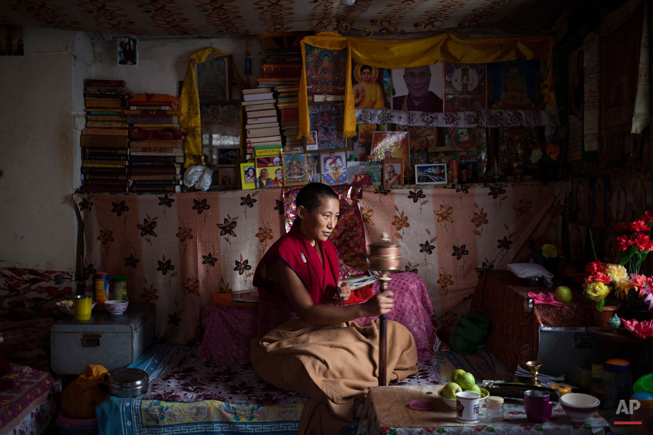  In this Saturday, Sept. 27, 2014 photo, an Exile Tibetan nun Namdak Choeying, 44, prays in her room that she shares with two other nuns in Dharmsala, India. Back home in Tibet she aspired to be a fully ordained nun and escaped to India in 2006. Her 