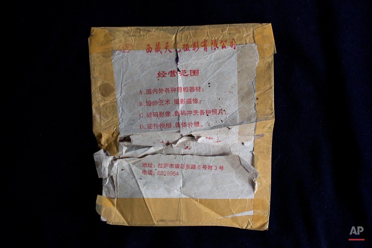  This Tuesday, Sept. 30, 2014 photo shows an envelope with Mandarin prints that profile a photography company in Lhasa, preserved by Tibetan exile Dolma Kyi, 21, after she received a letter from her family in it in New Delhi, India. Kyi escaped from 