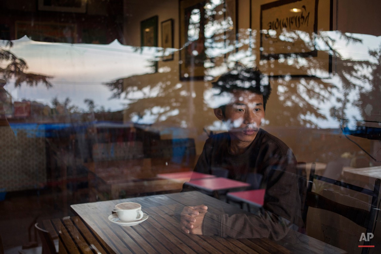  In this Tuesday, Sept. 30, 2014 photo, Tashi Dorjee  27, sits in a coffee shop in Dharmsala, India. He fled with his brother as a four-year-old in 1991. Dorjee says he missed his parents most when he was in school, especially when everyone went home