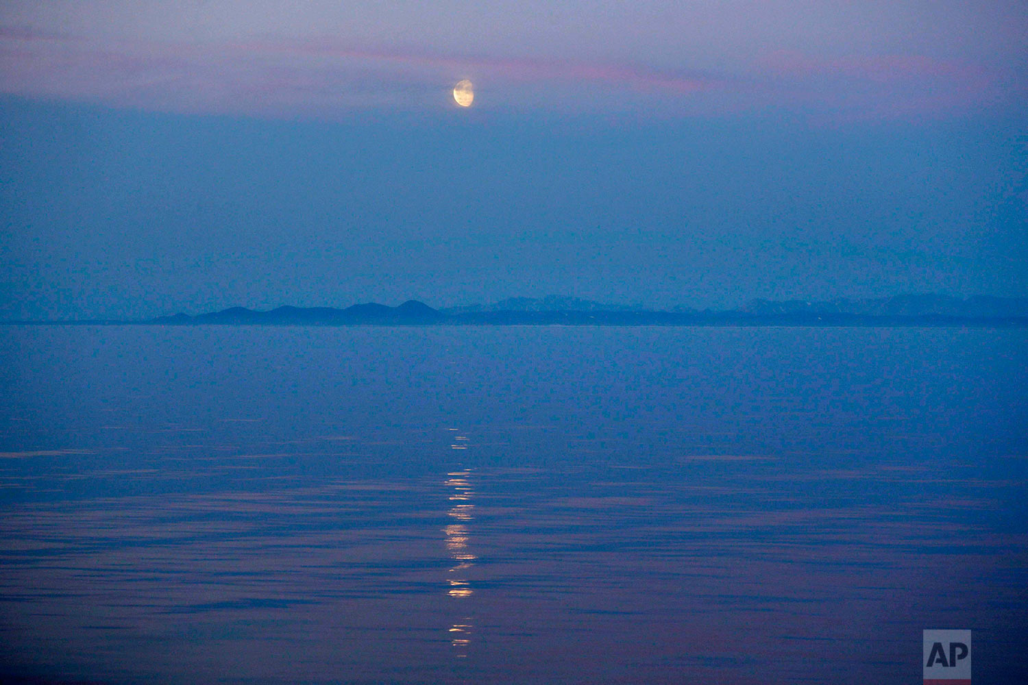  The moon rises over the coast of Alaska as the Finnish icebreaker MSV Nordica sails along the international date line through the Bering Strait, Friday, July 14, 2017. The international date line is an imaginary border that runs through the middle o