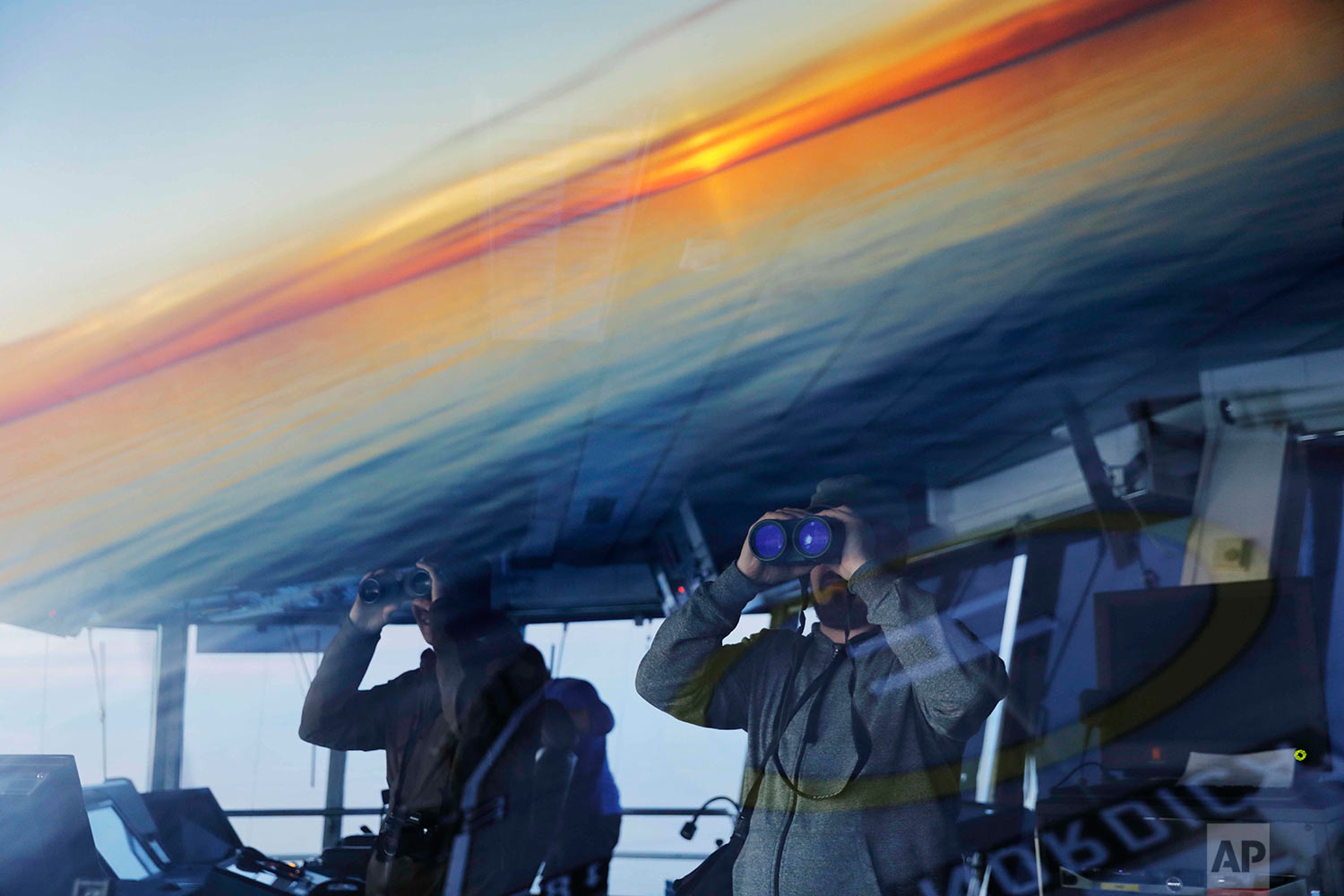  Researchers look toward the midnight sun while approaching the American island of Little Diomede, Alaska, and the Russian island of Big Diomede, as the Finnish icebreaker MSV Nordica sails along the international date line through the Bering Strait,