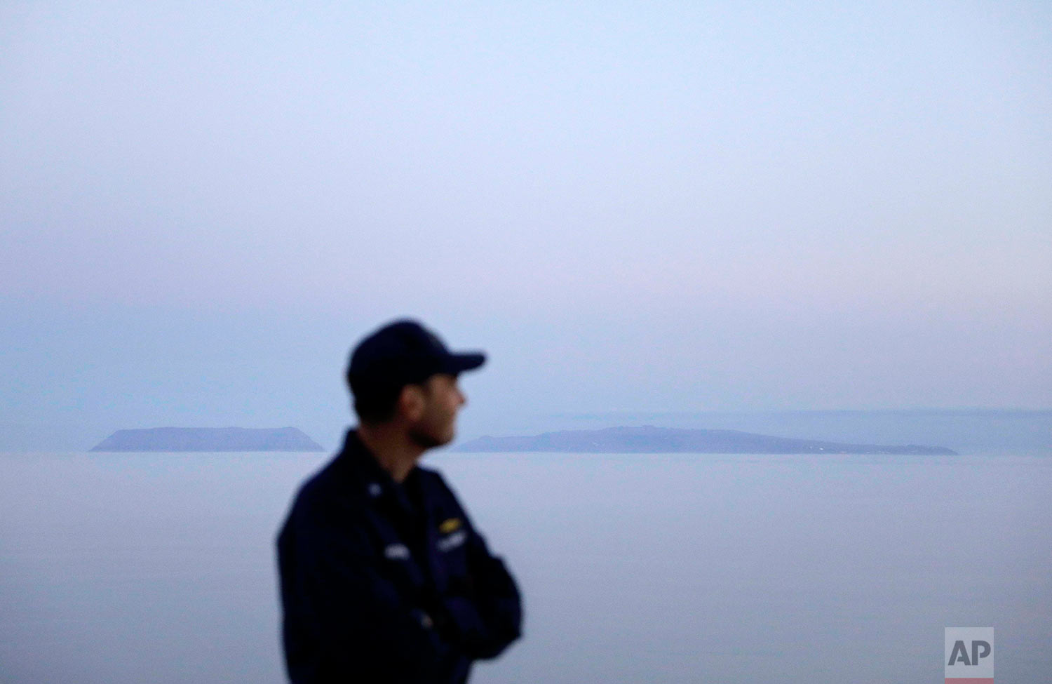  Cmdr. Bill Woityra, manager for domestic and polar icebreaking for the U.S. Coast Guard, looks out to sea while passing the American island of Little Diomede, Alaska, left, and the Russian island of Big Diomede, right, as the Finnish icebreaker MSV 