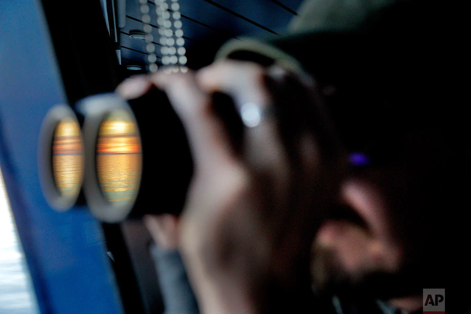 Researcher Ari Laakso looks to the horizon through binoculars under the midnight sun while approaching the Bering Strait, which divides the United States and Russia, as the Finnish icebreaker MSV Nordica sails along the international date line, Friday, July 14, 2017. The international date line is an imaginary border that runs through the middle of the Pacific Ocean and marks the boundary between calendar dates, effectively making it the zero-line for the planet’s time zones. (AP Photo/David Goldman)