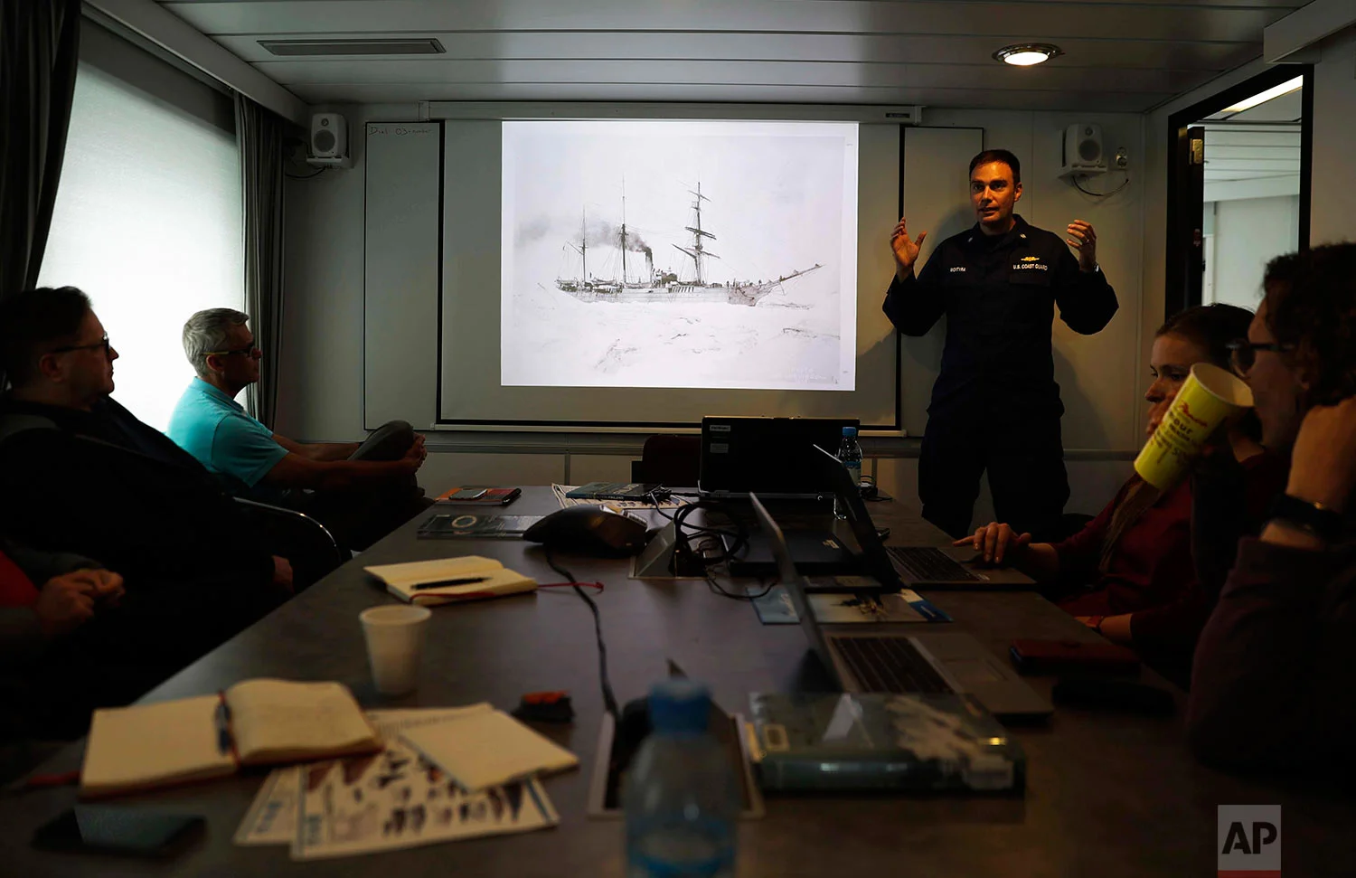Cmdr. Bill Woityra, manager for domestic and polar icebreaking for the U.S. Coast Guard, right, gives a presentation on the history of U.S. ice breaking aboard the Finnish icebreaker MSV Nordica as it sails in the North Pacific Ocean toward the Bering Sea, Sunday, July 9, 2017. (AP Photo/David Goldman)