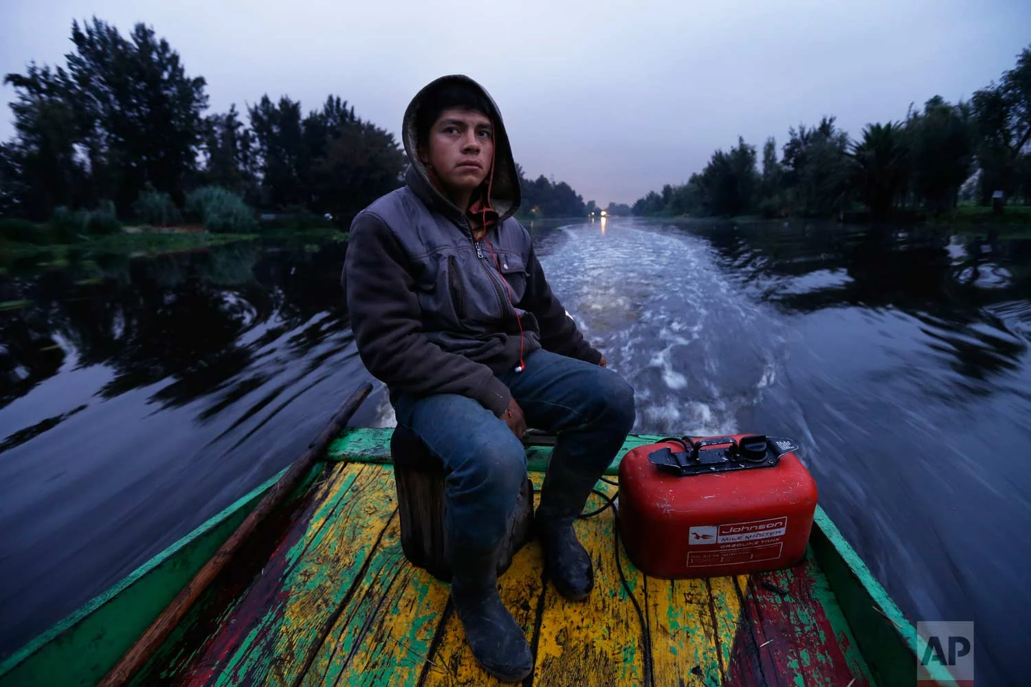 In this July 13, 2017 photo, Gerardo Cristobal navigates his boat as he ferries farmers and laborers to their floating farms called "chinampas" in Xochimilco, Mexico City. (AP Photo/Marco Ugarte)