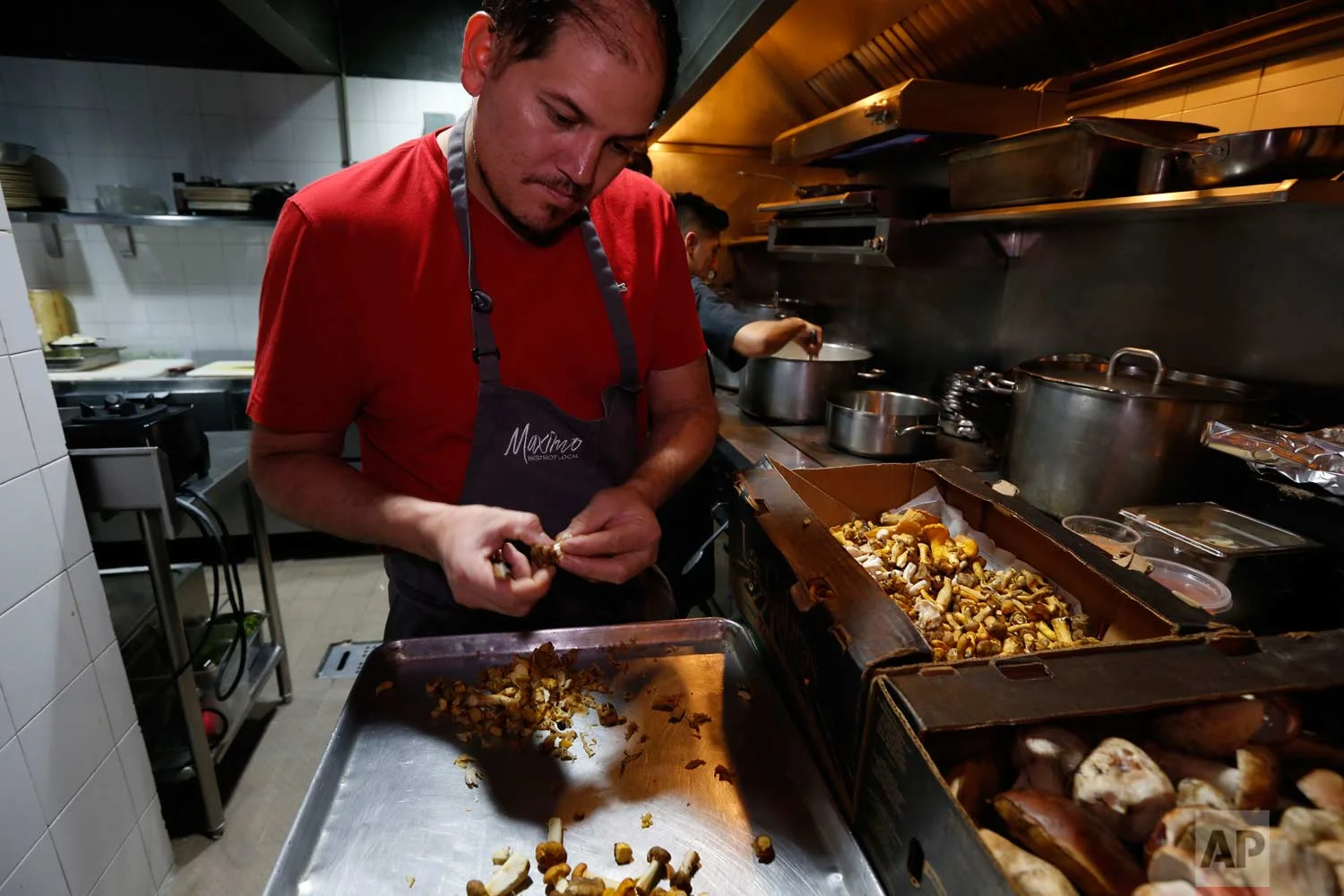 In this July 13, 2017 photo, chef Eduardo Garcia, founder of Maximo Bistrot and former migrant worker in the US, cuts mushrooms at his restaurant in Mexico City. (AP Photo/Marco Ugarte)