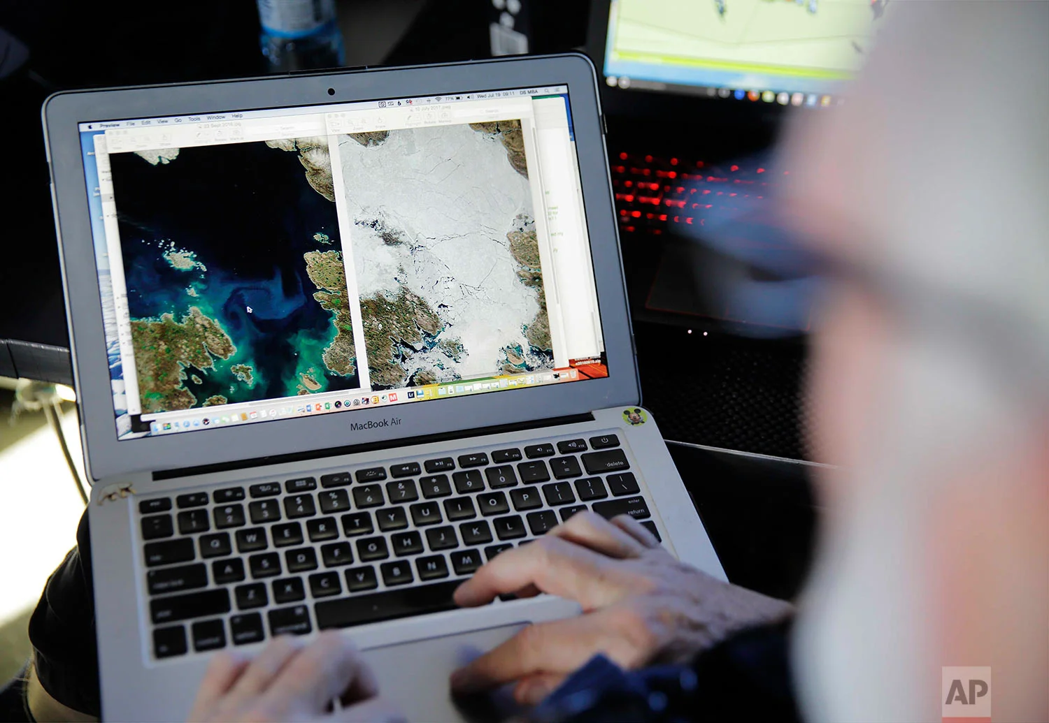 Canadian ice navigator, David "Duke" Snider compares satellite ice imagery from September 2016 on the left to last week's, on the right, for the same area where the Finnish icebreaker MSV Nordica will be traversing through the Arctic's Northwest Passage, Wednesday, July 19, 2017. (AP Photo/David Goldman)