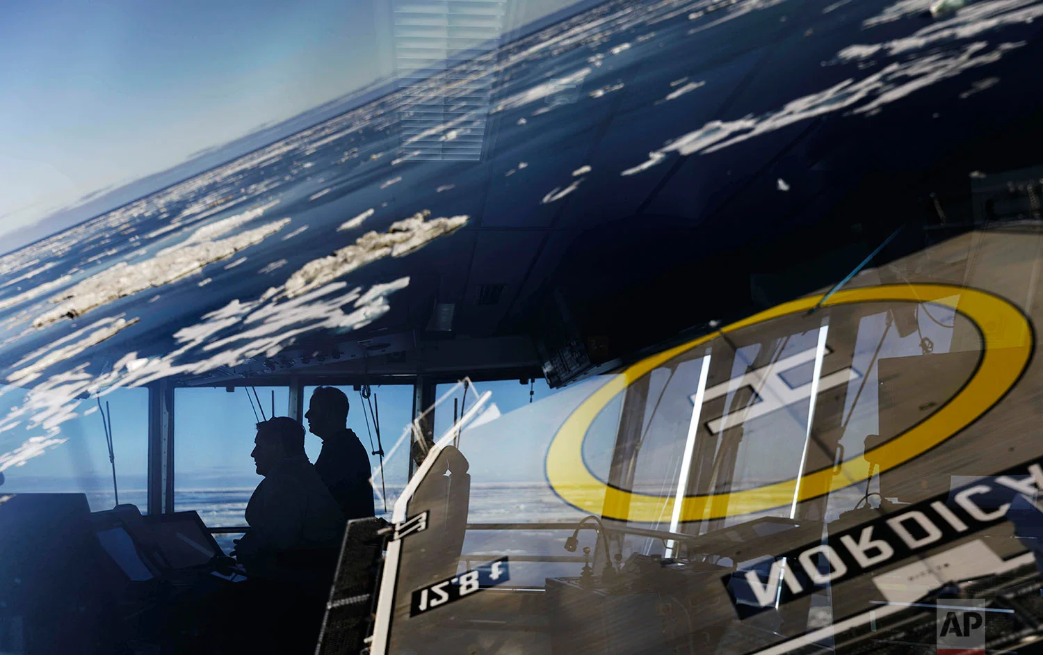 Master Mariner Jyri Viljanen, left, captain of the Finnish icebreaker MSV Nordica and first officer Jukka Vuosalmi, are seen through the window of the bridge navigating through ice floating on the Beaufort Sea while traversing the Arctic's Northwest Passage, Sunday, July 16, 2017. There are more than 100 dedicated icebreaking ships around the world. Russia has over 40 _ by far the most _ due in part to its long Arctic coastline. (AP Photo/David Goldman)