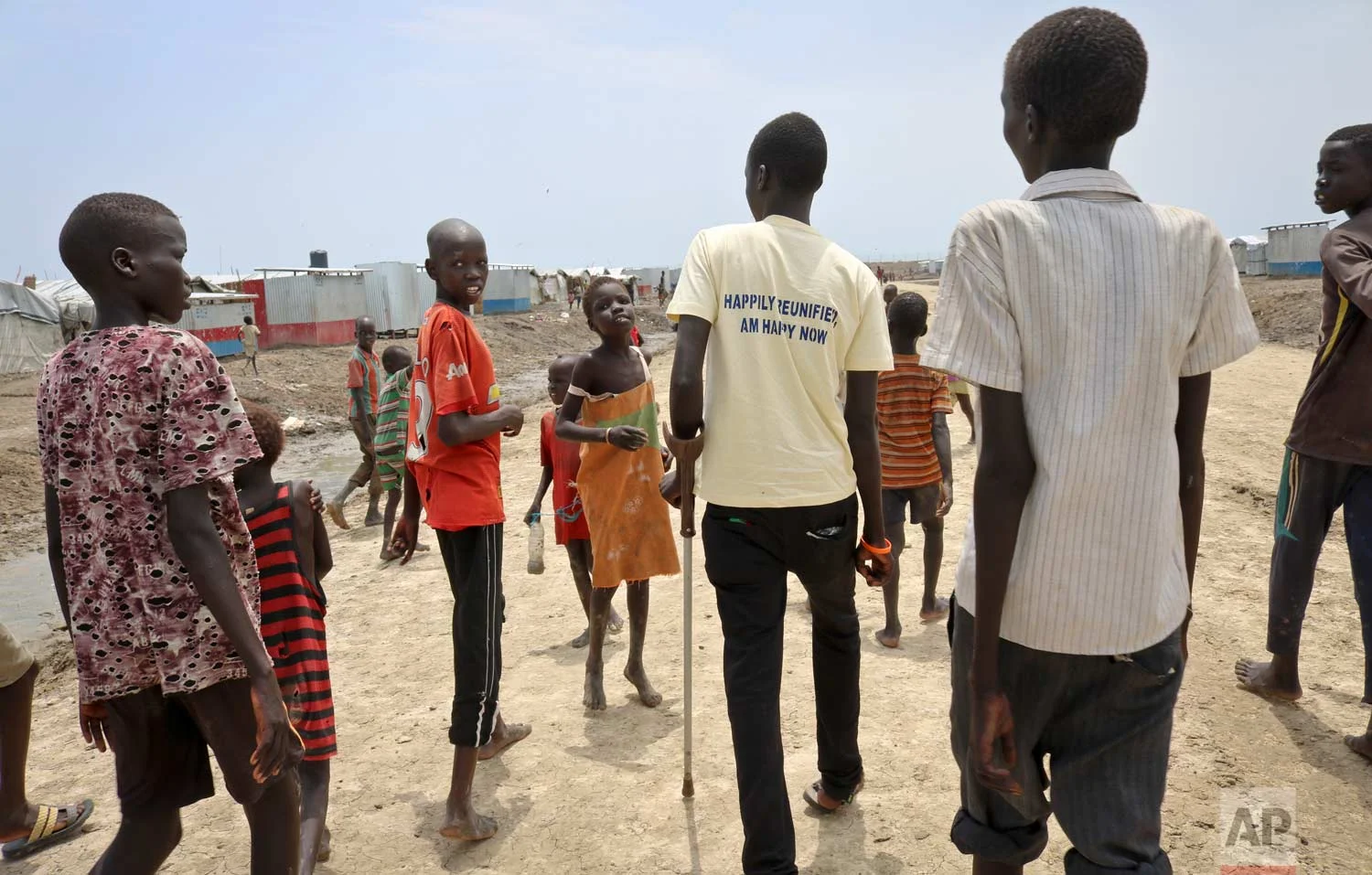 In this photo taken Friday, May 26, 2017, former child soldier James, accompanied by one of his sisters and friends, walks towards his mother's house to be reunited and see her for the first time in 3 years, at a protection of civilians site in Bentiu, South Sudan. (AP Photo/Sam Mednick)