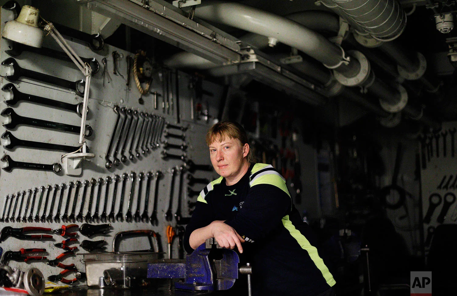 Electrician Kaija Peuhkuri, 42, stands for a portrait in the machine shop of the Finnish icebreaker MSV Nordica as the ship sails north in the Bering Sea toward the Arctic, Wednesday, July 12, 2017. Peuhkuri started as a cook on ships over 20 years ago before going back to school and becoming an electrician on icebreakers in 2009. Growing up on a farm working on machines, she prefers working away at sea as opposed to commuting to a job at home. "I don't want to do this every morning," she said of having to drive to work. "Here, I come downstairs every morning, have a cup of coffee and I'm at work." (AP Photo/David Goldman)