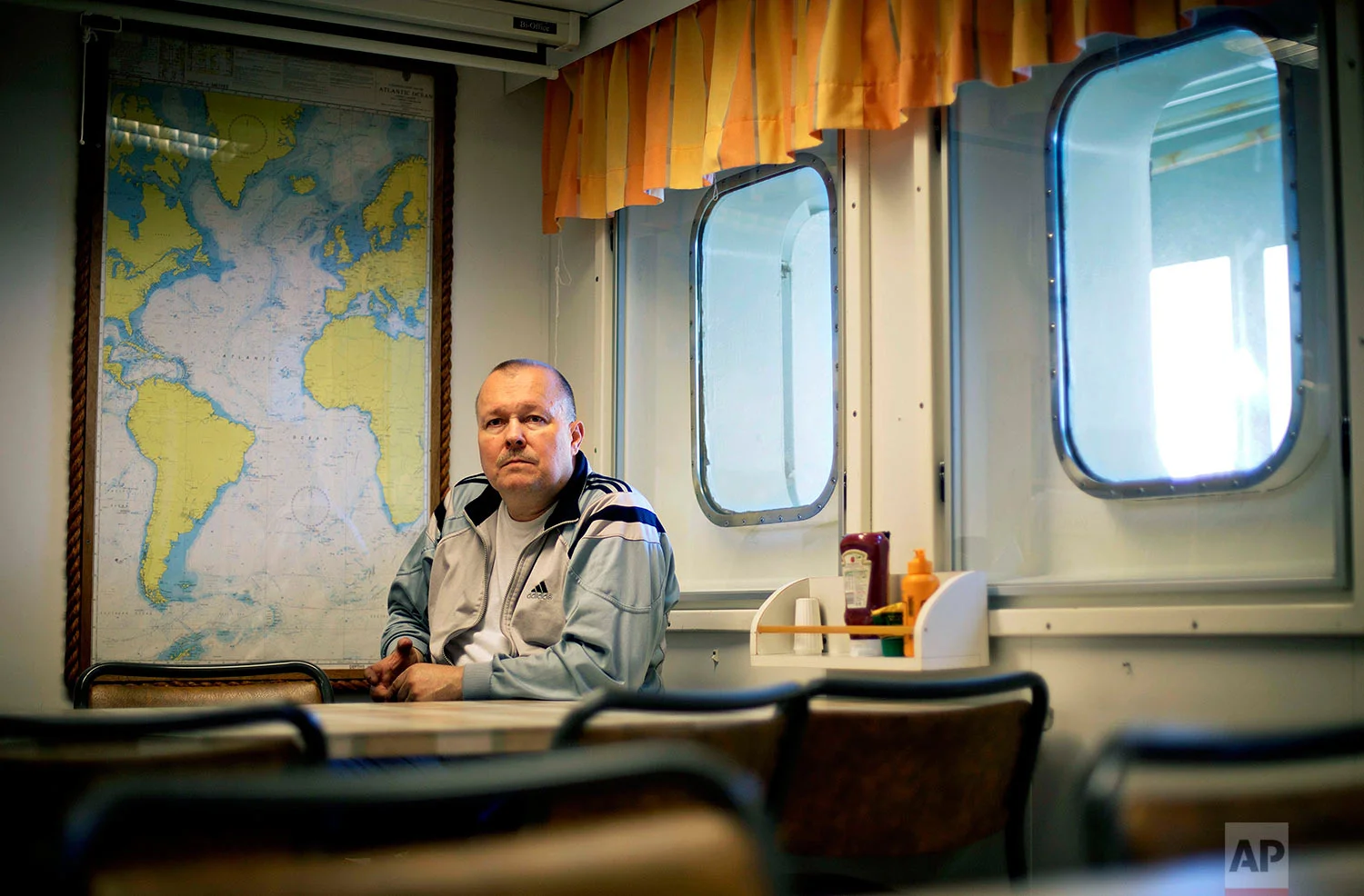 Engine repairman Jari Jarvinen, 58, sits for a portrait in the mess hall after finishing a night shift aboard the Finnish icebreaker MSV Nordica as it sails in the North Pacific Ocean toward the Bering Strait, Tuesday, July 11, 2017. Jarvinen started working on boats over 30 years ago. "I've been there before. For me it's normal work," said Jarvinen of the Northwest Passage. "I like it though. Not everyday is the same. You look outside the window and it's always a different place." (AP Photo/David Goldman)