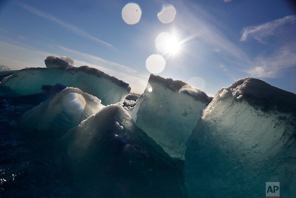  Broken blocks of sea ice emerge from under the hull of the Finnish icebreaker MSV Nordica as it sails through the Victoria Strait while traversing the Arctic's Northwest Passage, Friday, July 21, 2017. Sea ice forms when the top layer of water reach