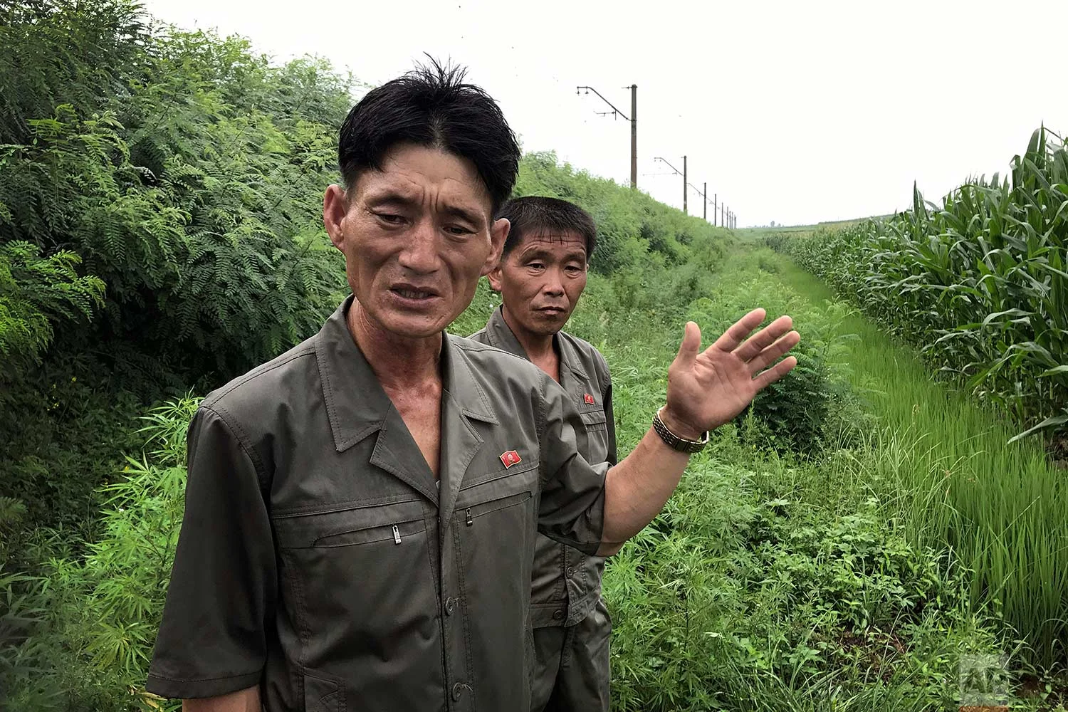 In this Friday, July 21, 2017, photo, Yom Hak Chol, 44, manager of the 4th work team of the Pohang cooperative farm, left, and Paek Song Guk, 44, who found an unexploded bomb near the railway which runs through Hamhung from Pyongyang to the northeastern port of Chongjin, speak to The Associated Press in Hamju county, North Korea. (AP Photo/Wong Maye-E)