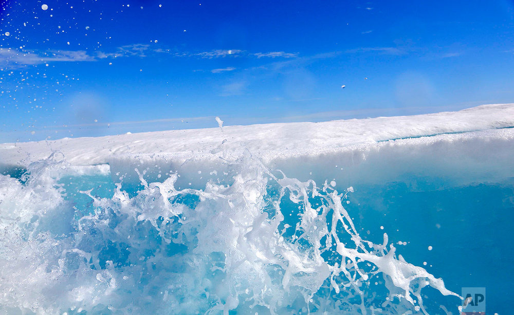  Water sprays as a block of sea ice is broken from the hull of the Finnish icebreaker MSV Nordica as it sails the Victoria Strait while traversing the Arctic's Northwest Passage, Friday, July 21, 2017. Sea ice forms when the top layer of water reache