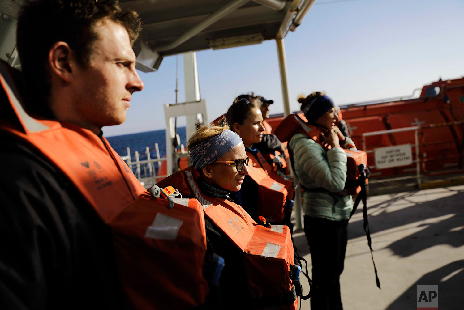 Researchers Scott Joblin, from left, and Ilona Mettiainen, wear life vests during a safety drill with fellow personnel aboard the Finnish icebreaker MSV Nordica as it sails the North Pacific Ocean to traverse the Arctic's Northwest Passage, Thursday, July 6, 2017. (AP Photo/David Goldman)