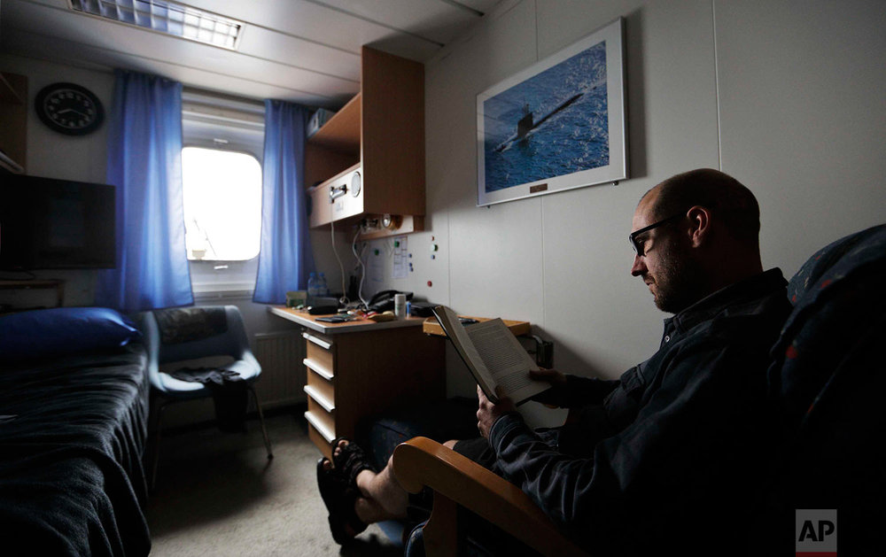  In this Sunday, July 9, 2017 photo, boatswain Henri Helminen reads a book in his cabin after working a shift aboard the Finnish icebreaker MSV Nordica as it sails the North Pacific Ocean to traverse the Northwest Passage through the Canadian Arctic 