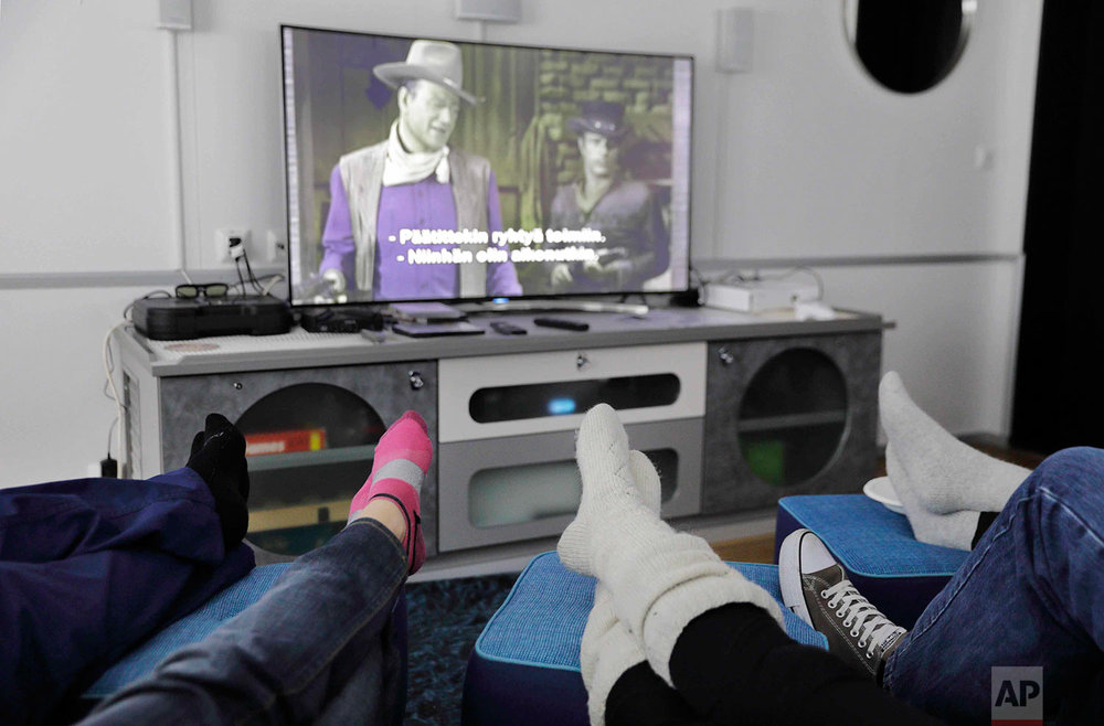  In this Saturday, July 15, 2017 photo, researchers aboard the Finnish icebreaker MSV Nordica put their feet up while watching the movie "El Dorado" starring actor John Wayne as the ship sails the Chukchi Sea to traverse the Northwest Passage through