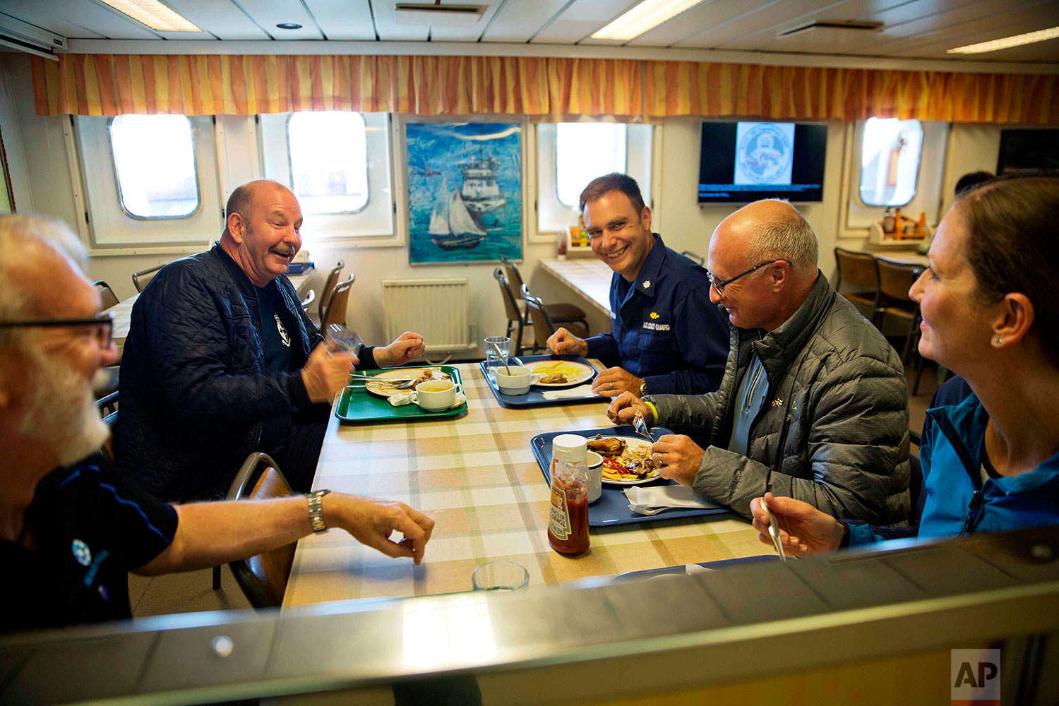  In this Monday, July 10, 2017 photo, ice navigator Capt. David "Duke" Snider, from left, Canadian Coast Guard Capt. Victor Gronmyr, U.S. Coast Guard Cmdr. Bill Woityra, assistant ice navigator Nigel Greenwood, and biologist Paula von Weller talk ove