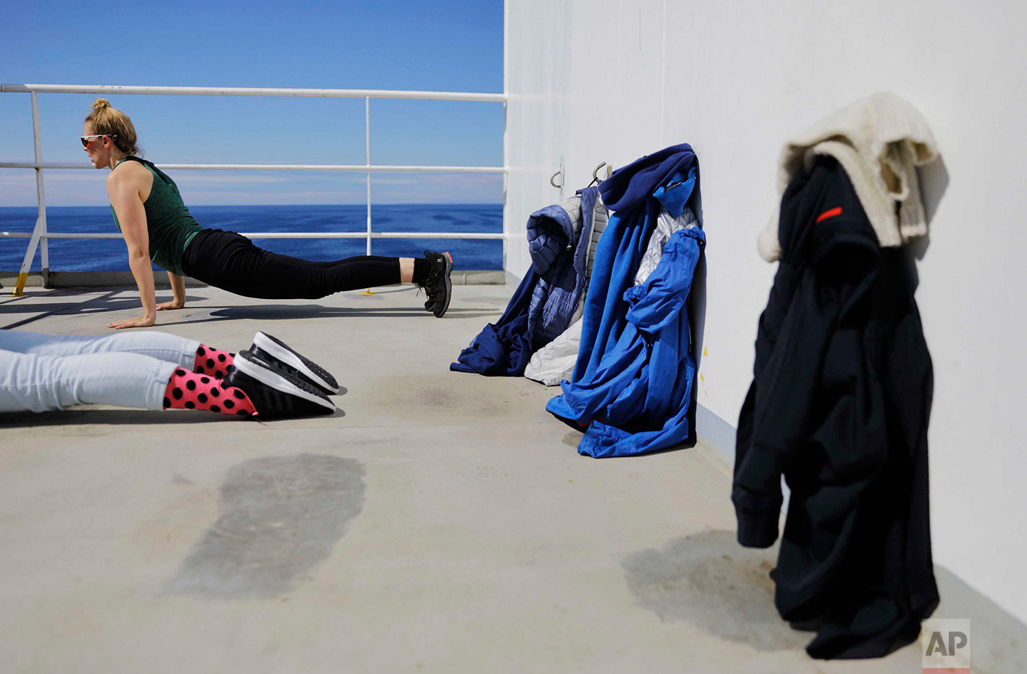  In this Thursday, July 13, 2017 photo, researchers Tiina Jaaskelainen, right, and Daria Gritsenko do yoga in the warm weather aboard the Finnish icebreaker MSV Nordica as it sails the Bering Sea to traverse the Northwest Passage through the Canadian