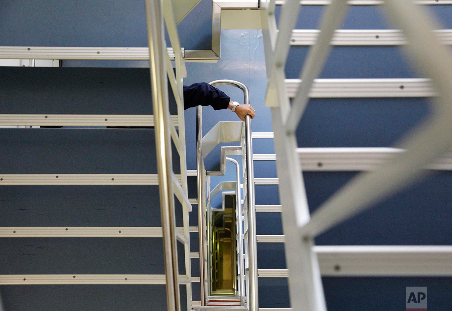  In this Wednesday, July 12, 2017 photo, Nigel Greenwood, assistant ice navigator and retired Royal Canadian Navy rear admiral, climbs down the six flights of stairs from the bridge to the mess hall as he heads down for dinner aboard the Finnish iceb