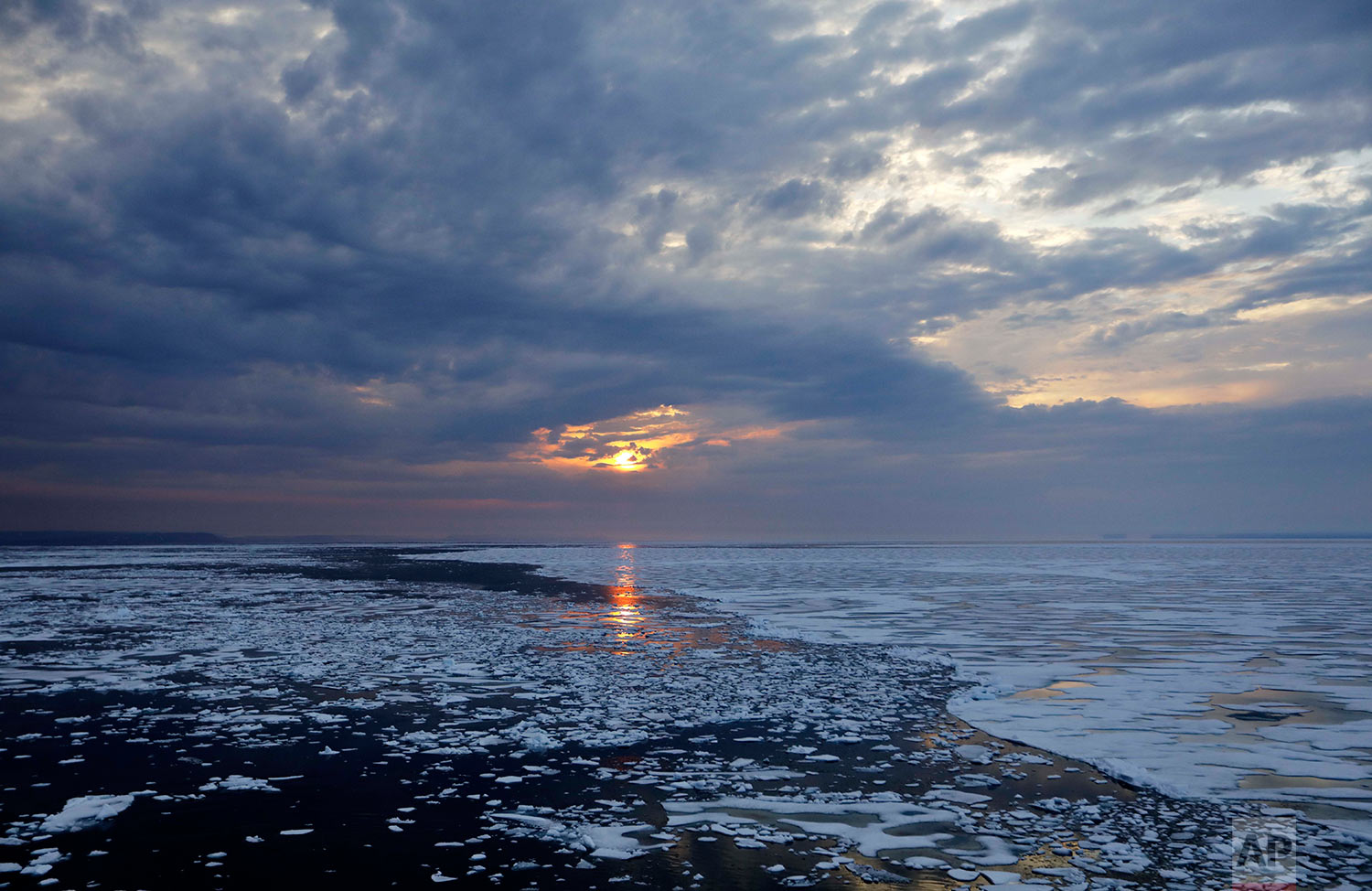 The sun sets over melting sea ice on Peel Sound along the Northwest Passage in the Canadian Arctic Archipelago, Sunday, July 23, 2017. Because of global warming, more sea ice is being lost each summer than is being replenished in winters. Although sea ice is likely to continue forming each winter it may be restricted to even higher latitudes. Less sea ice coverage also means that less sunlight will be reflected off the surface of the ocean in a process known as the albedo effect. The oceans will absorb more heat, further fueling global warming. (AP Photo/David Goldman)