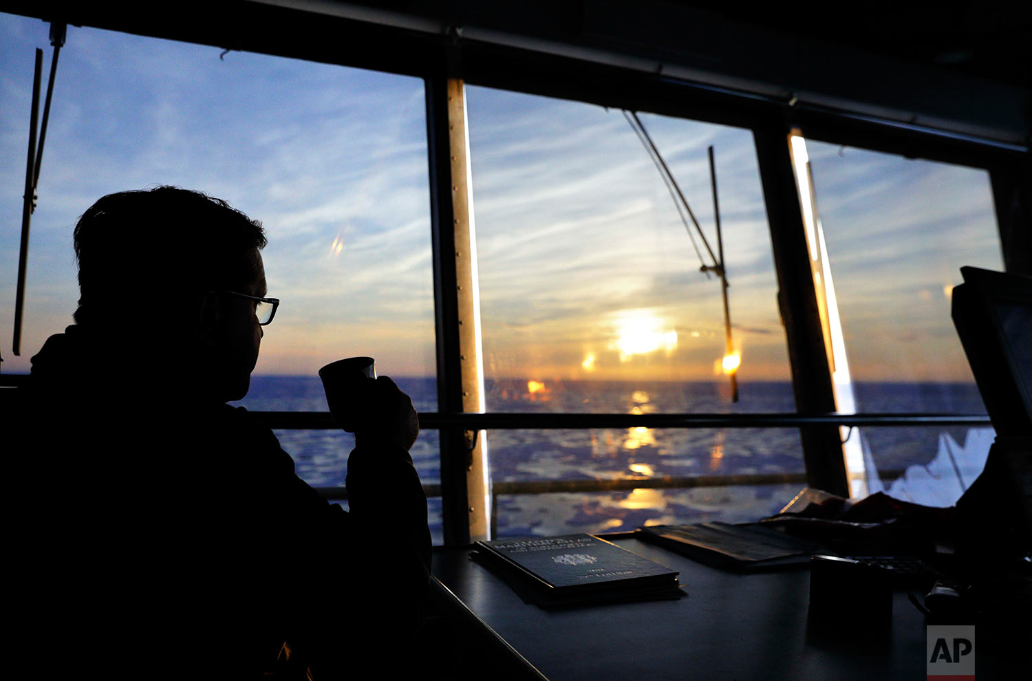  Sunlight is cast over the sea ice at midnight as Master Mariner Jyri Viljanen, captain of the Finnish icebreaker MSV Nordica, sips a cappuccino while overseeing the navigation of the Northwest Passage through the Victoria Strait in the Canadian Arct