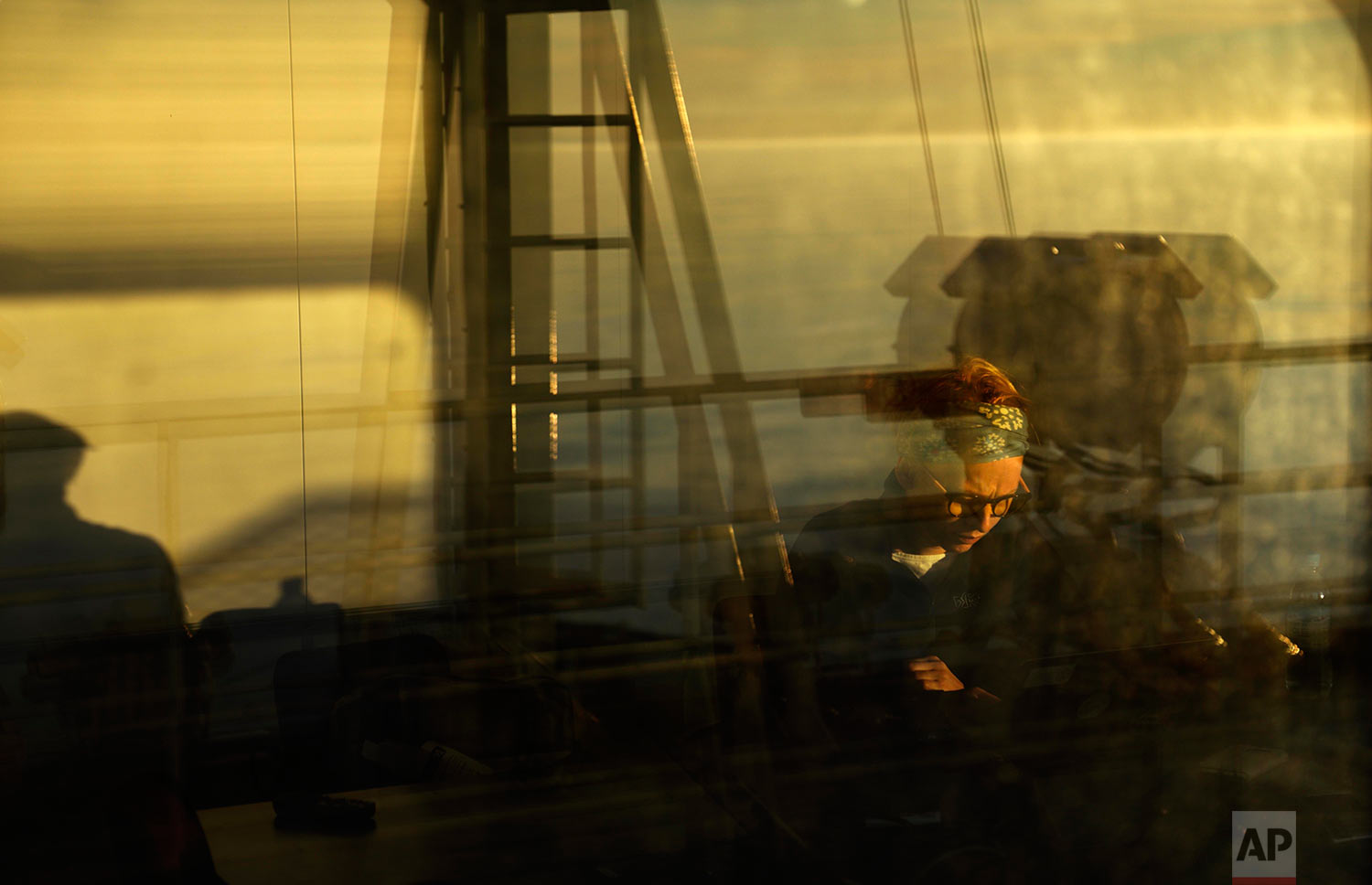  The sun shines through the window at midnight as researcher Ilona Mettiainen reads in a room overlooking an observation deck on the Finnish icebreaker MSV Nordica as it sails the Bering Sea toward the Canadian Arctic Archipelago to traverse the Nort
