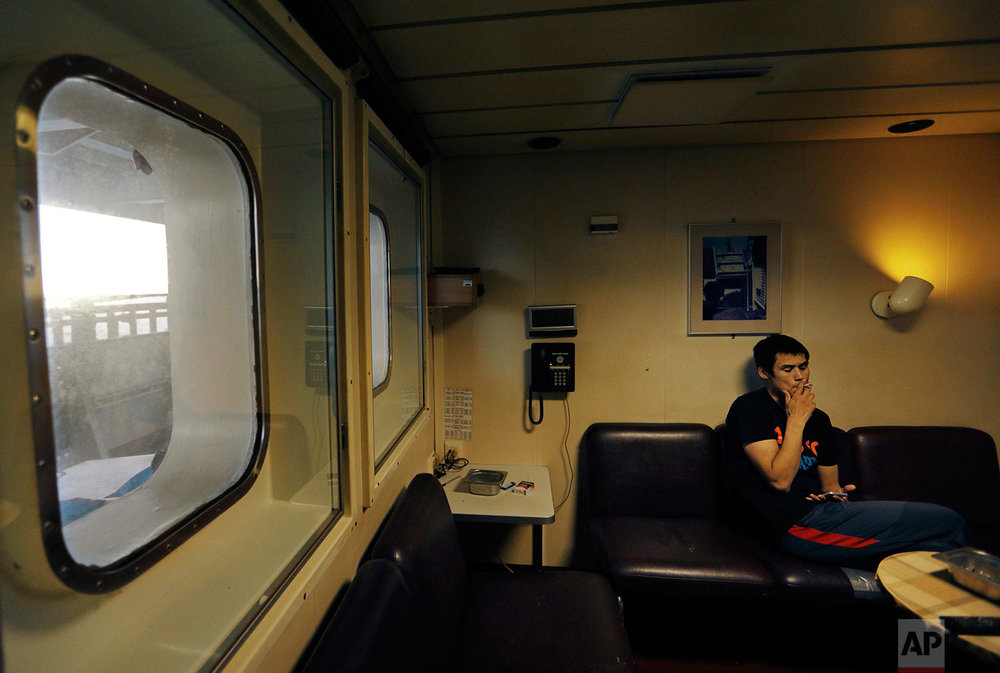  Daylight is seen out the window at midnight as trainee David Kullualik smokes a cigarette before turning in for the night aboard the Finnish icebreaker MSV Nordica while traversing the Northwest Passage though Baffin Bay in the Canadian Arctic Archi