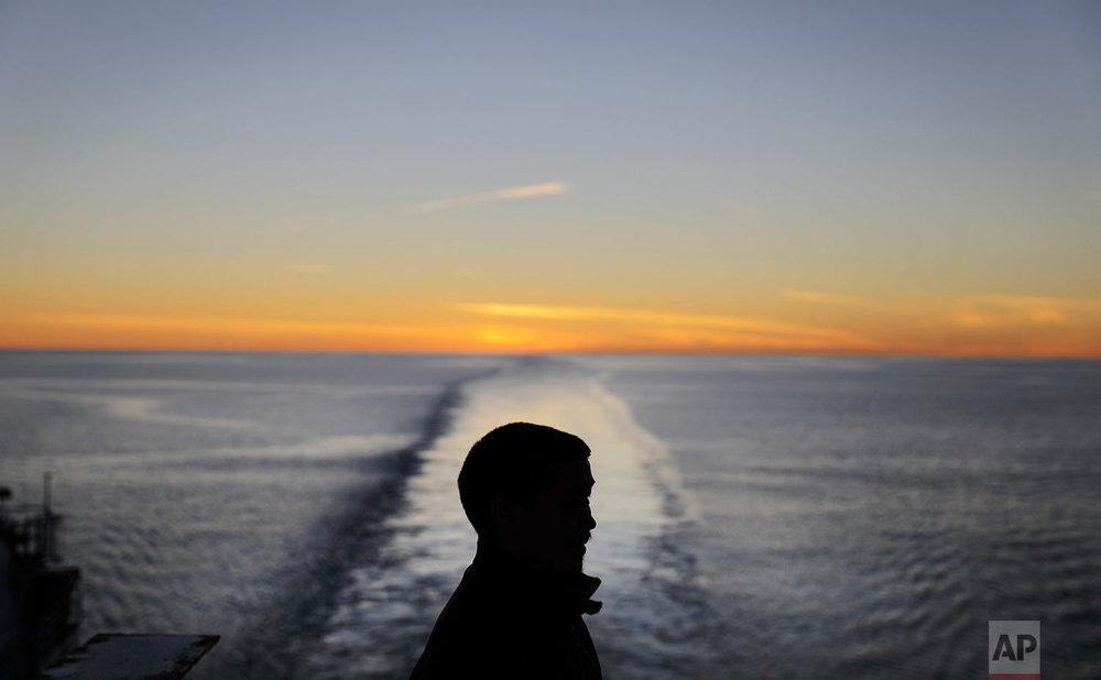  The sun dips below the horizon at midnight as trainee Maatiusi Manning takes in the view from aboard the Finnish icebreaker MSV Nordica as it sails toward Greenland after traversing the Northwest Passage through the Canadian Arctic Archipelago early