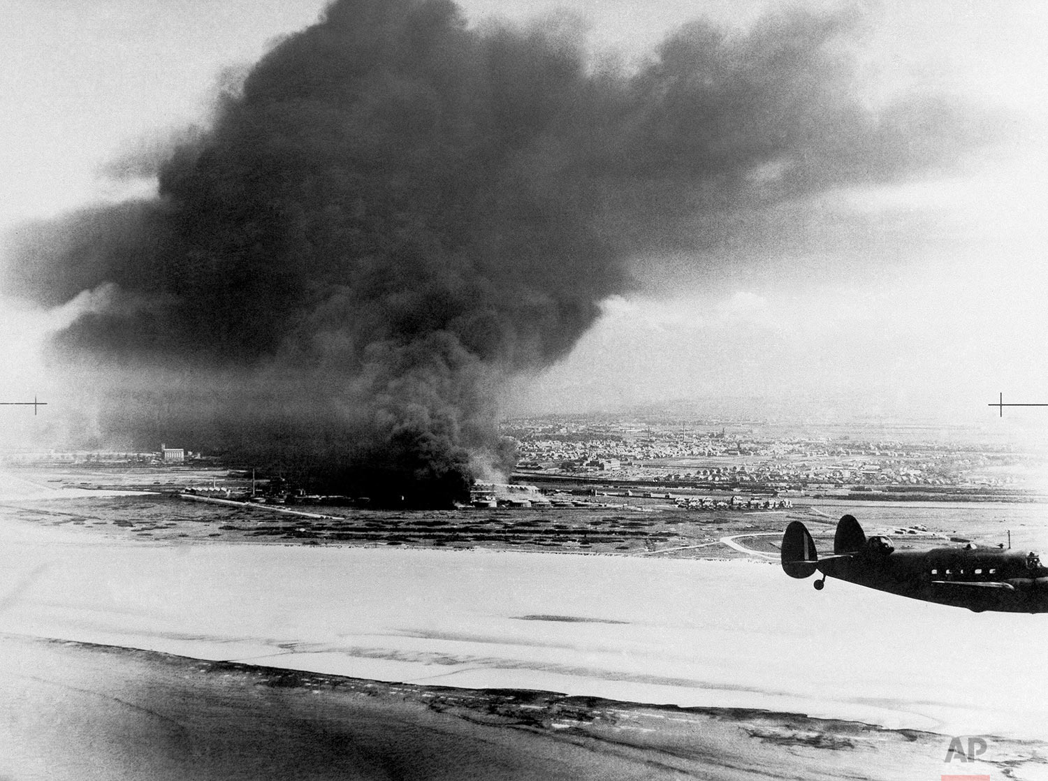  Dunkirk from the shore showing two burning oil tanks with Lockheed Hudson coastal command patrol plane in foreground on June 10, 1940 in France. (AP Photo) 