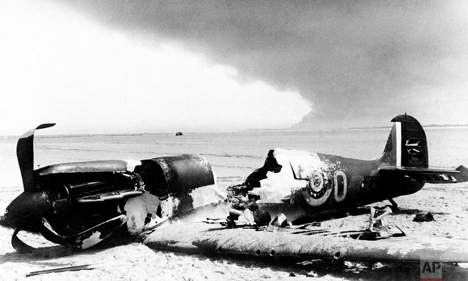  A British Spitfire fighter lays with its cockpit blasted out, after it crashed to the beach at Dunkirk, France on June 6, 1940, the last stand port of the Allied forces which fled from Flanders. Smoke from burning Dunkirk may be seen in the backgrou