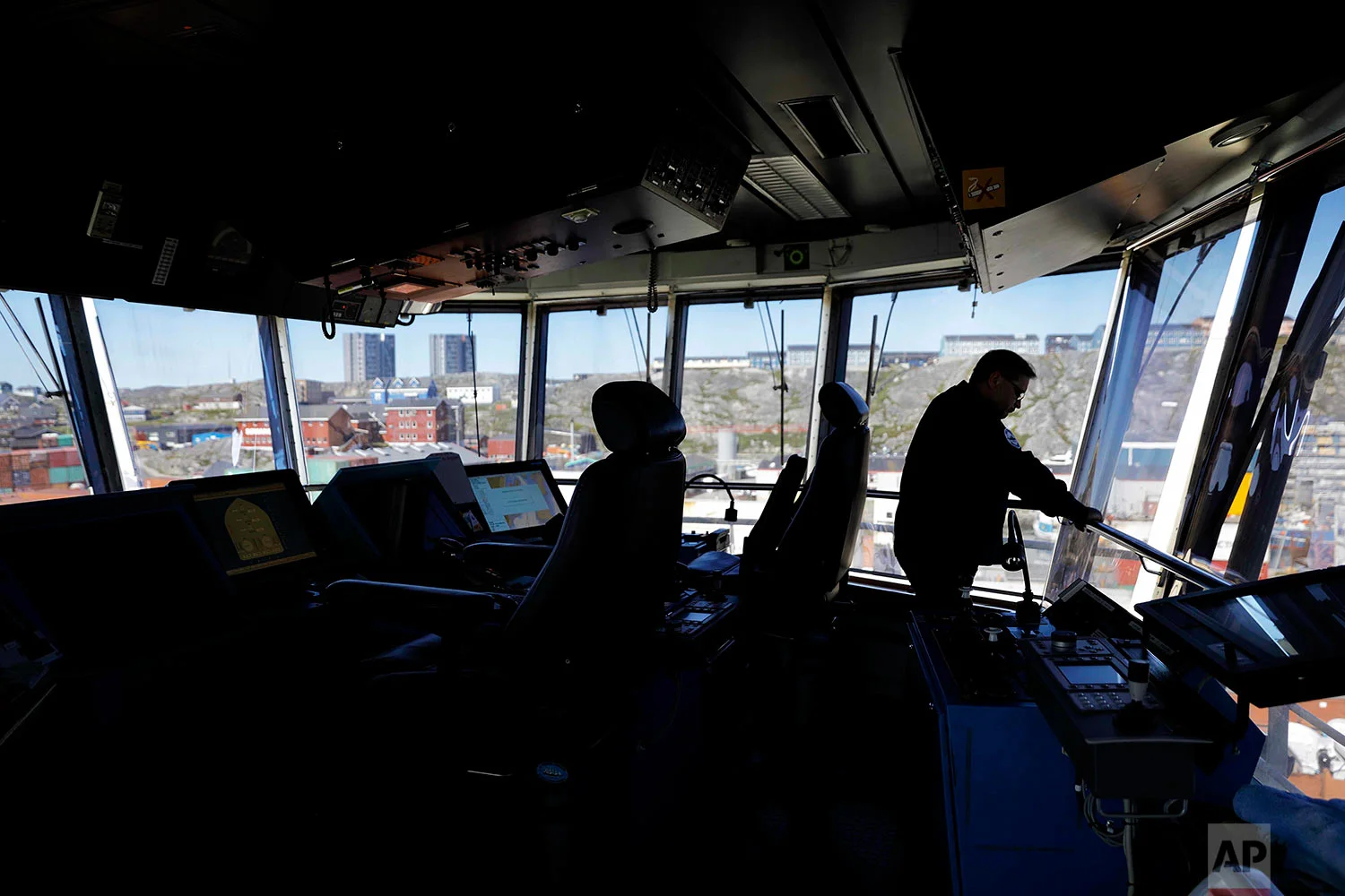 Master Mariner Jyri Viljanen, captain of the Finnish icebreaker MSV Nordica, looks out from the bridge after docking the ship in Nuuk, Greenland, as it arrives after traversing the Northwest Passage through the Canadian Arctic Archipelago, Saturday, July 29, 2017. After 24 days at sea and a journey spanning more than 10,000 kilometers (6,214 miles), the MSV Nordica has set a new record for the earliest transit of the fabled Northwest Passage. The once-forbidding route through the Arctic, linking the Pacific and the Atlantic oceans, has been opening up sooner and for a longer period each summer due to climate change. (AP Photo/David Goldman)