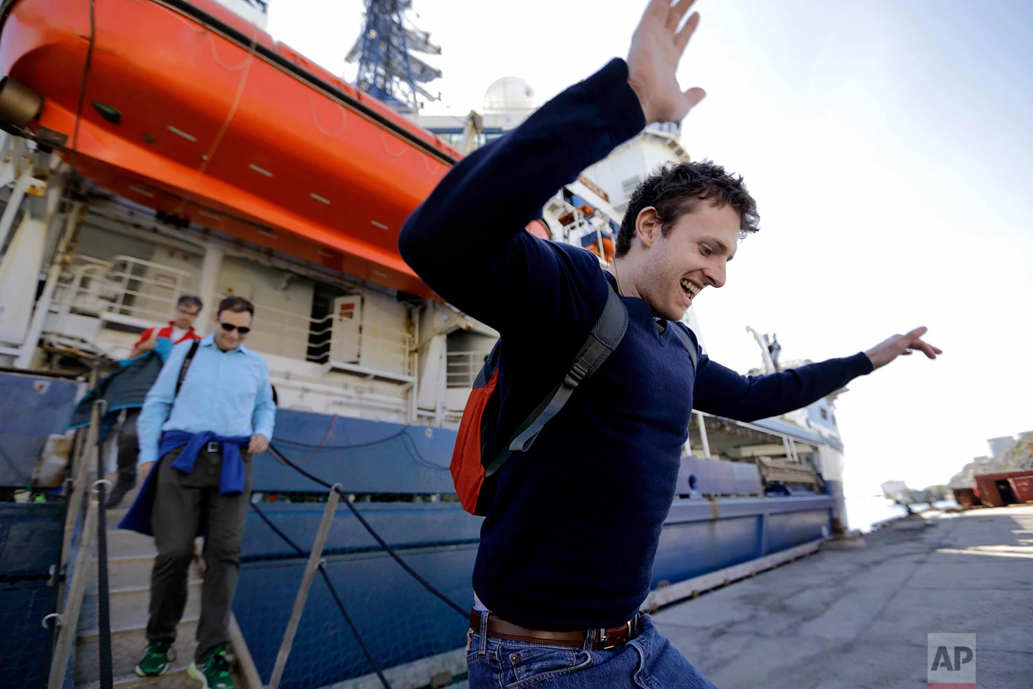Researcher Scott Joblin jumps onto land for the first time since setting sail aboard the Finnish icebreaker MSV Nordica as it arrives into Nuuk, Greenland, after traversing the Northwest Passage through the Canadian Arctic Archipelago, Saturday, July 29, 2017. After 24 days at sea and a journey spanning more than 10,000 kilometers (6,214 miles), the MSV Nordica has set a new record for the earliest transit of the fabled Northwest Passage. The once-forbidding route through the Arctic, linking the Pacific and the Atlantic oceans, has been opening up sooner and for a longer period each summer due to climate change. (AP Photo/David Goldman)