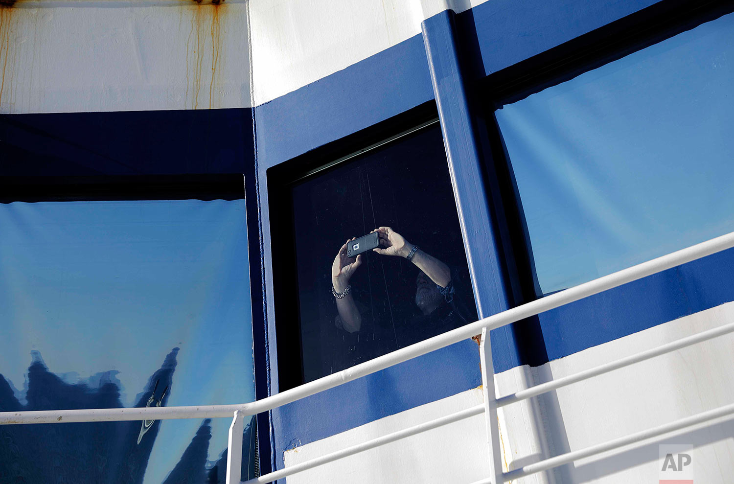  Canadian ice navigator, David "Duke" Snider takes a photo from the bridge as the Finnish icebreaker MSV Nordica arrives into Nuuk, Greenland, after traversing the Northwest Passage through the Canadian Arctic Archipelago, Saturday, July 29, 2017. Af