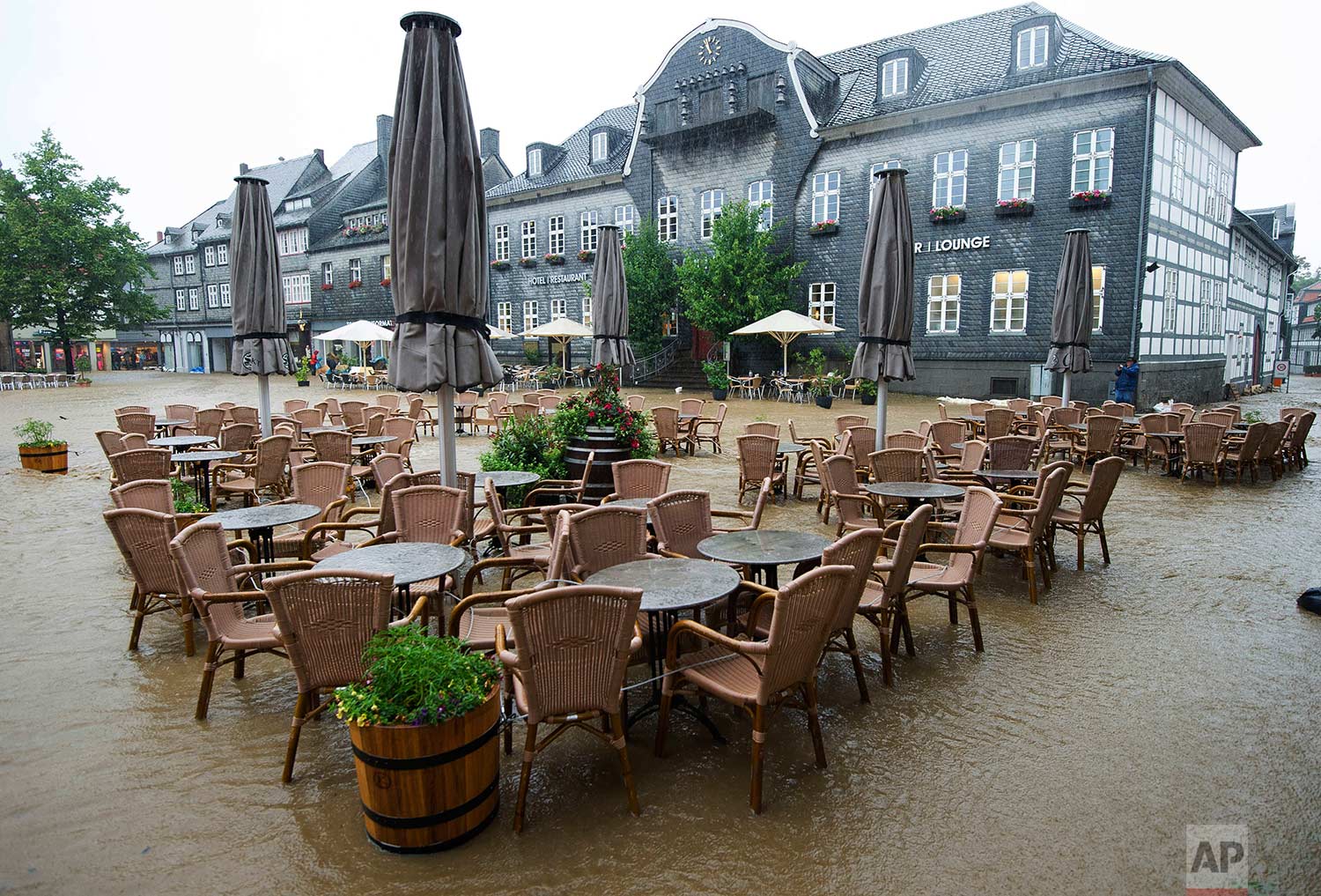 Tables and chairs of a cafe sit empty in the flooded Marktplatz square in Goslar, Germany, Wednesday, July 26, 2017. (Swen Pfoertner/dpa via AP)