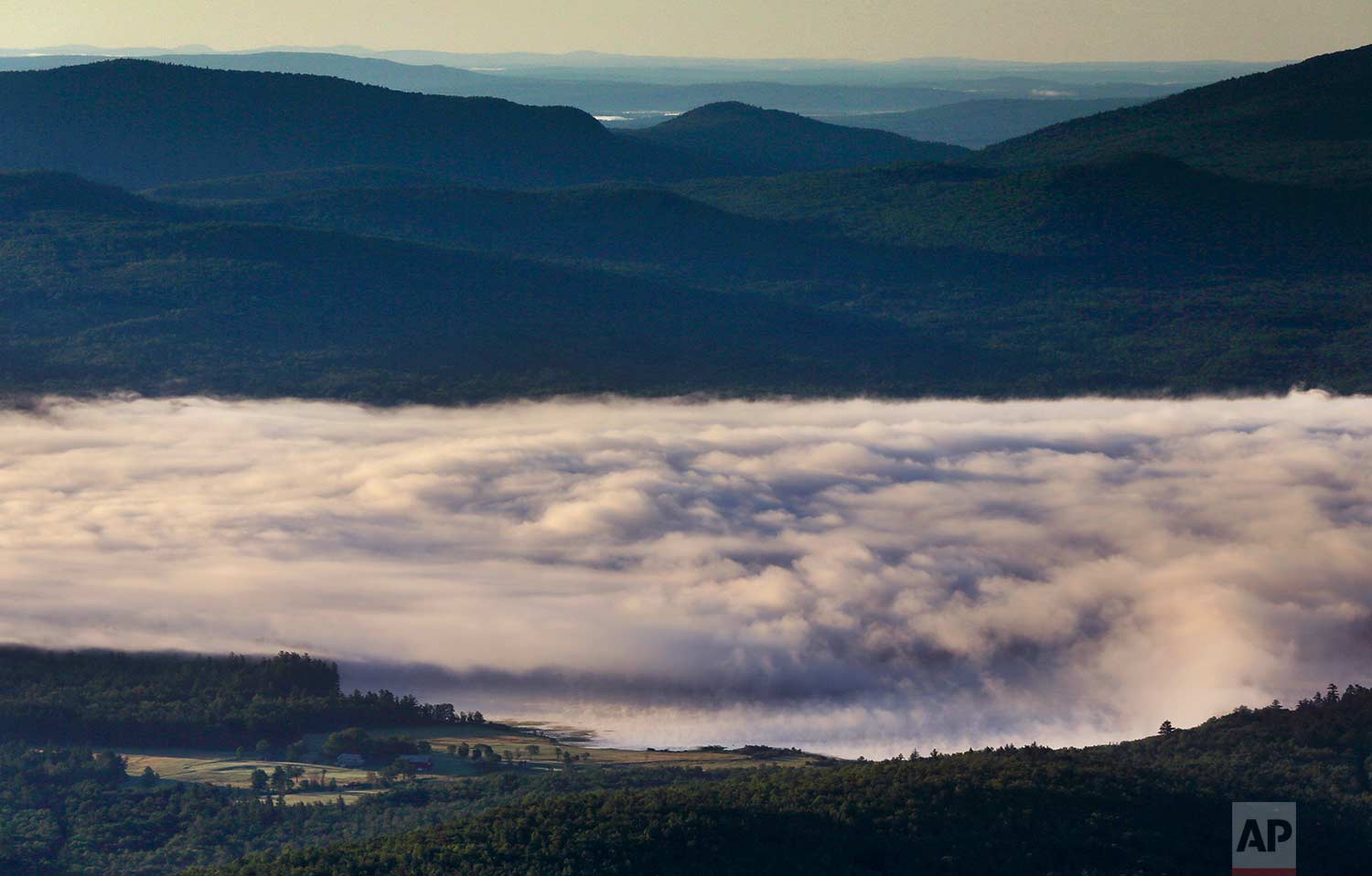 A billowy layer of fog hovers over Webb Lake on a chilly morning where the temperature dropped into the mid-40s, Wednesday, July 26, 2017, in Weld, Maine. (AP Photo/Robert F. Bukaty)