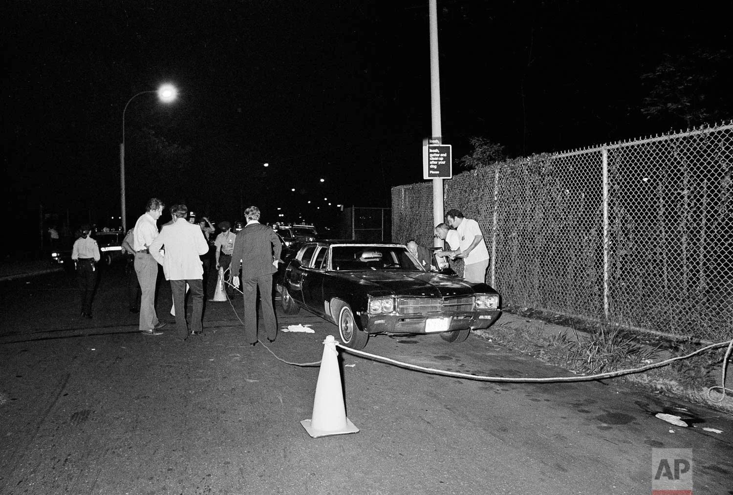 Police rope off the area around a car as they search for evidence in the early morning hours of July 31, 1977, after a gunman shot a young couple parked in a secluded lovers' lane in the Gravesend section of the Brooklyn borough of New York. Police believe it was another "Son of Sam" shooting. (AP Photo)