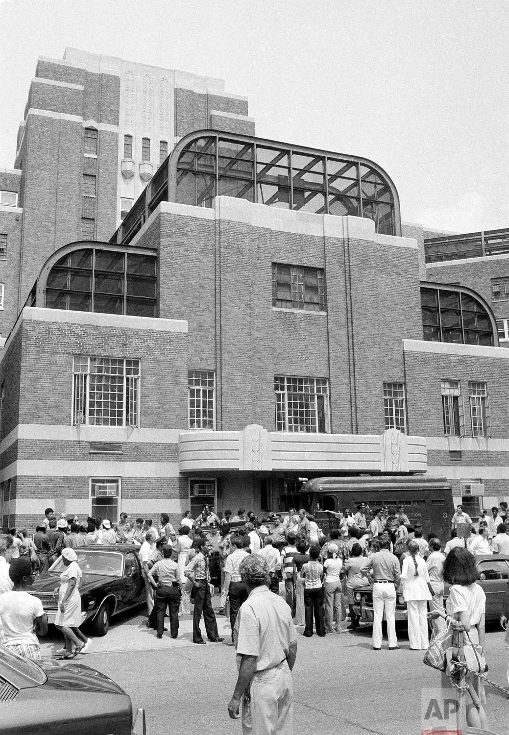 A crowd gathers outside Kings County hospital in the Brooklyn borough of New York, Thursday, Aug. 11, 1977 as a police van arrives. The van was carrying accused “.44 Caliber Killer”, David Berkowitz, to a mental ward at the hospital for observation. (AP Photo)