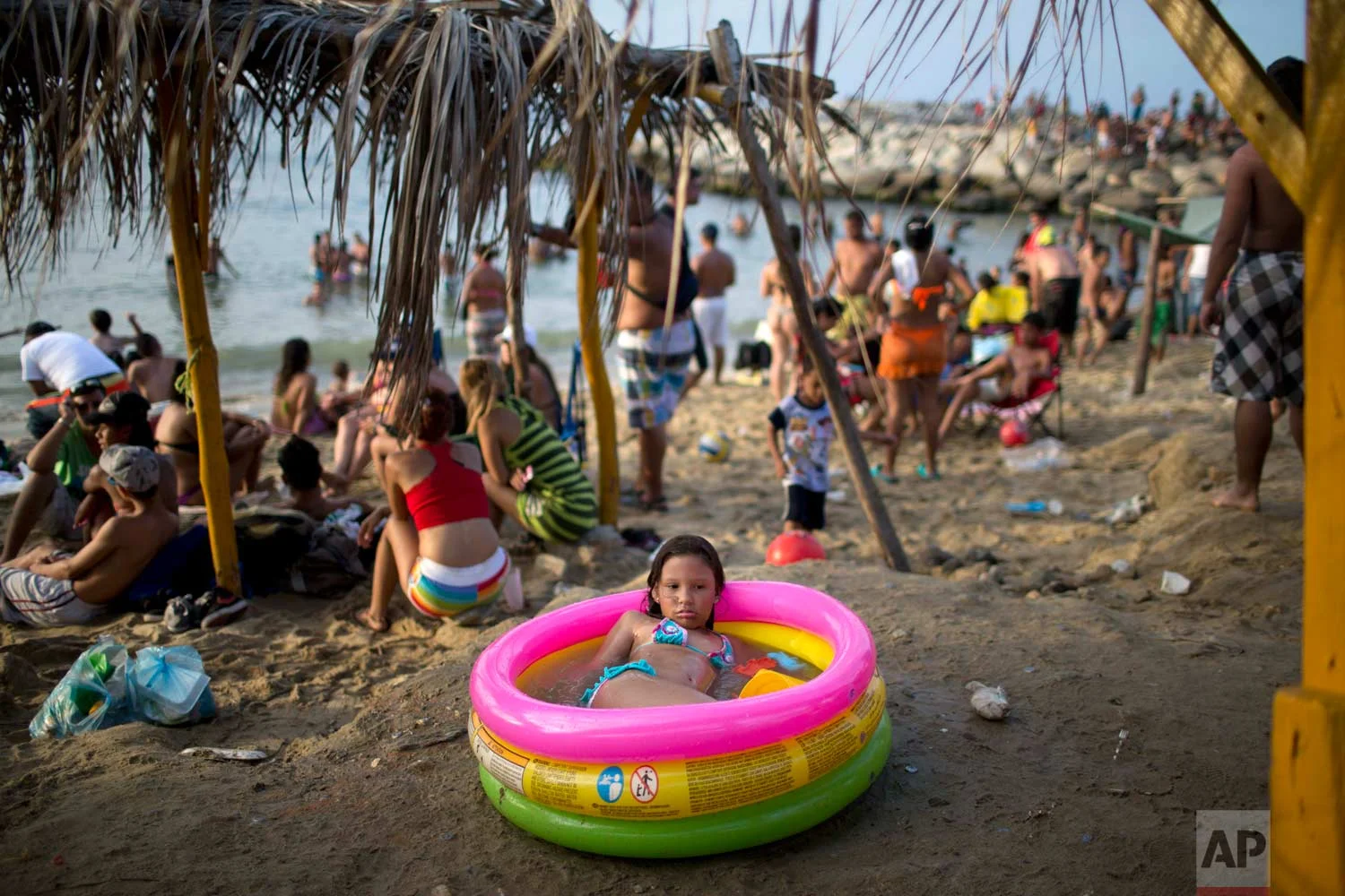 In this March 3, 2014 photo, a girl cools off in an inflatable swimming pool on the beach in La Guaira, Venezuela. (AP Photo/Rodrigo Abd)