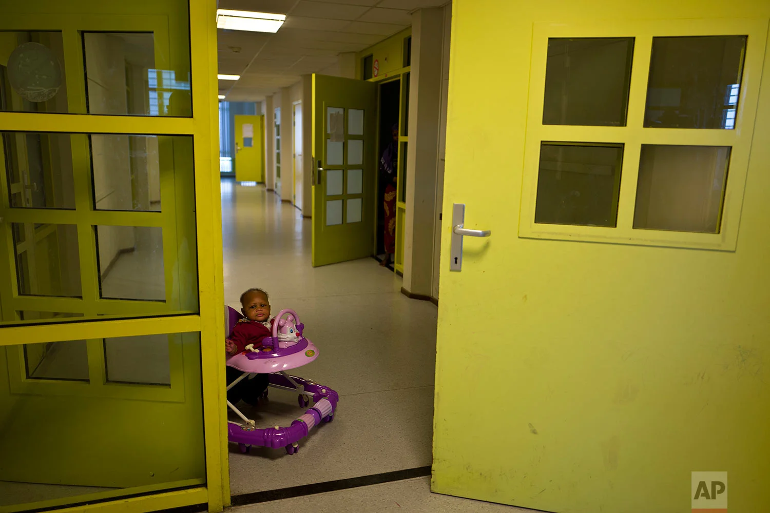 In this Tuesday, June 27, 2017 photo, Mariam Traore, an 8-month-year-old migrant from Ivory Coast, moves on a chair near her mother's room at the former prison of Bijlmerbajes, in Amsterdam, Netherlands. (AP Photo/Muhammed Muheisen)