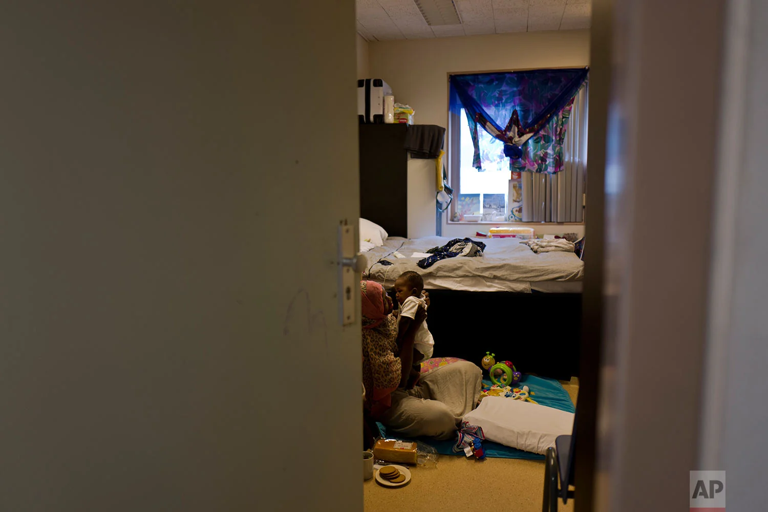 In this Monday, June 26, 2017 photo, Ugandan migrant, Mariam Nebas, 31, holds her 5-month-old son Imran at her room in the former prison of Bijlmerbajes in Amsterdam, Netherlands. (AP Photo/Muhammed Muheisen)