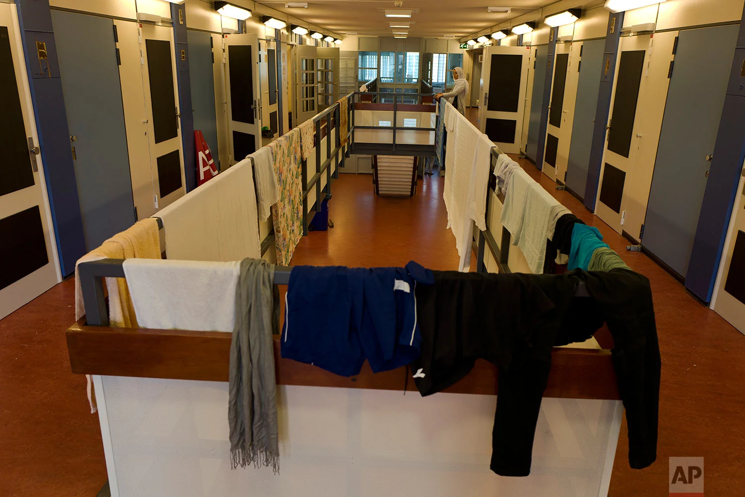 In this Thursday, June 29, 2017 photo, refugee Sondos Alnaji, 17, from Damascus, Syria, hangs her laundry outside her room at the former prison of Bijlmerbajes, in Amsterdam, Netherlands. (AP Photo/Muhammed Muheisen)