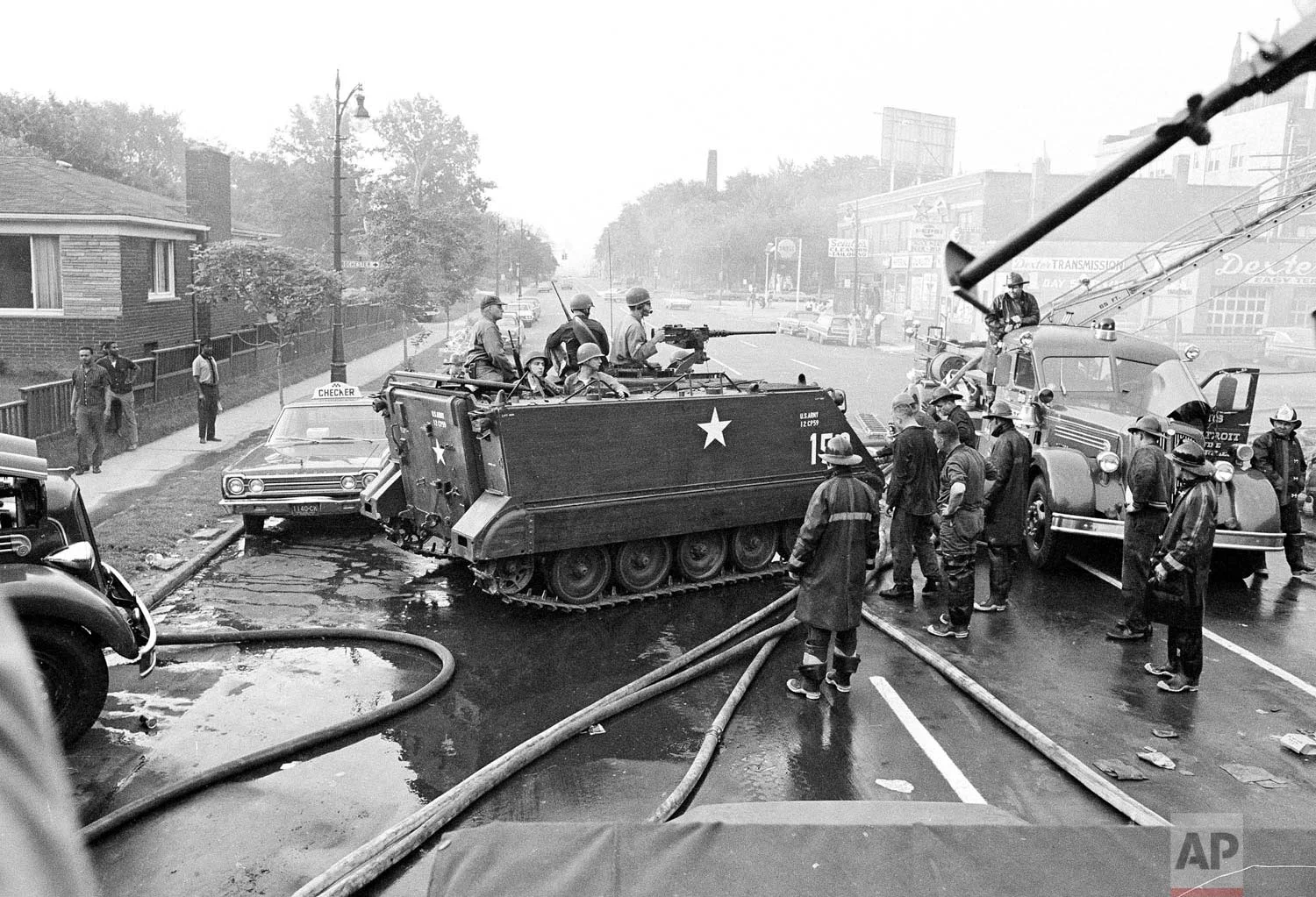 In this July 24, 1967 photo, National Guardsmen, called in to restore order by Gov. George Romney, stop their vehicle near a Detroit fire truck in the neighborhood that was ravaged by rioting the previous day. Many in the community blamed frustrations blacks felt toward the mostly white police, and city policies that pushed families into aging and over-crowded neighborhoods. (AP Photo)