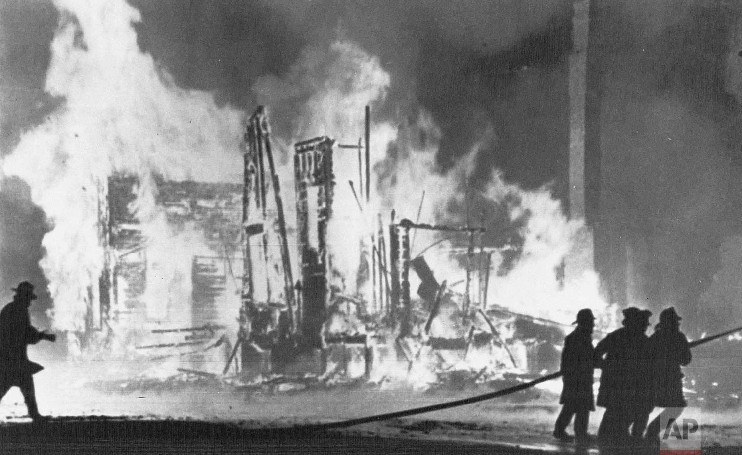 In this July 25, 1967 photo, firefighters try to control blazing buildings after riots in Detroit. Hundreds of fires were reported in the city. Five days of violence would leave 33 blacks and 10 whites dead, and more than 1,400 buildings burned. More than 7,000 people were arrested. (AP Photo)