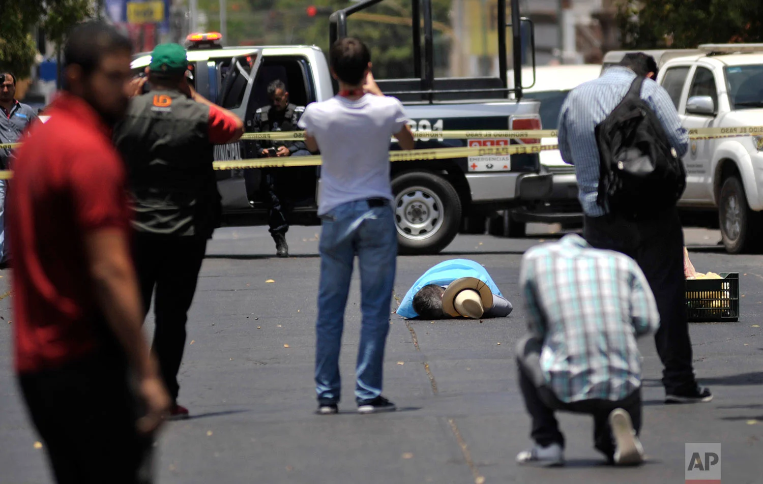 In this May 15, 2017 photo, people take photos of the body of slain journalist Javier Valdez, in Culiacan, Mexico. Mexico is now the world’s most lethal country for journalists, more even than war-torn Syria; their murderers are not brought to justice, despite a law passed in 2012 making it a federal crime to kill a journalist. It’s never successfully been used to convict a killer. (AP Photo/Fernando Brito)